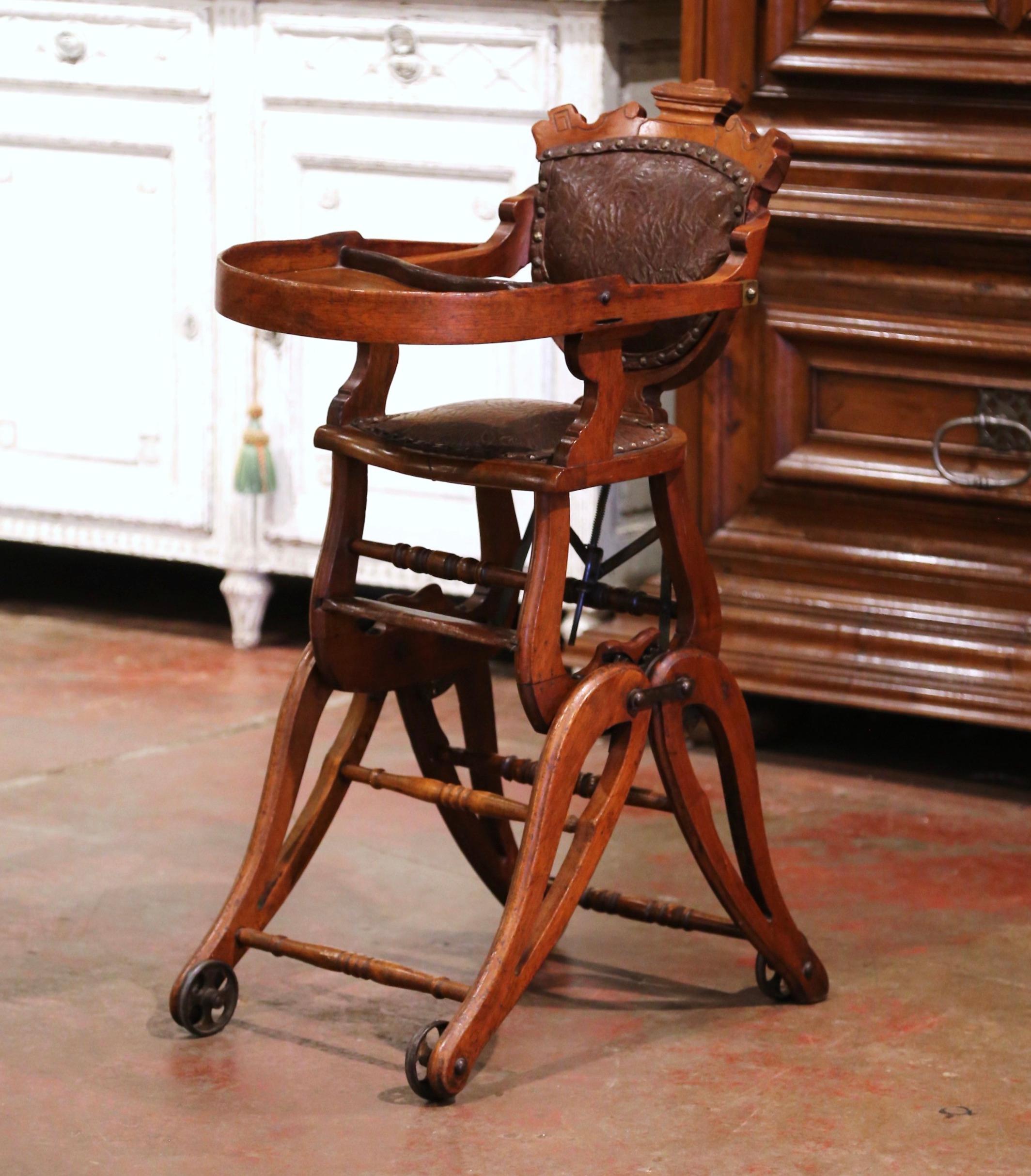 Feed your child in style or let him/her play in the antique and ingenious Victorian high chair! Crafted in England circa 1880 and made of walnut wood and upholstered with embossed brown leather, the charming baby chair has a double function; to feed