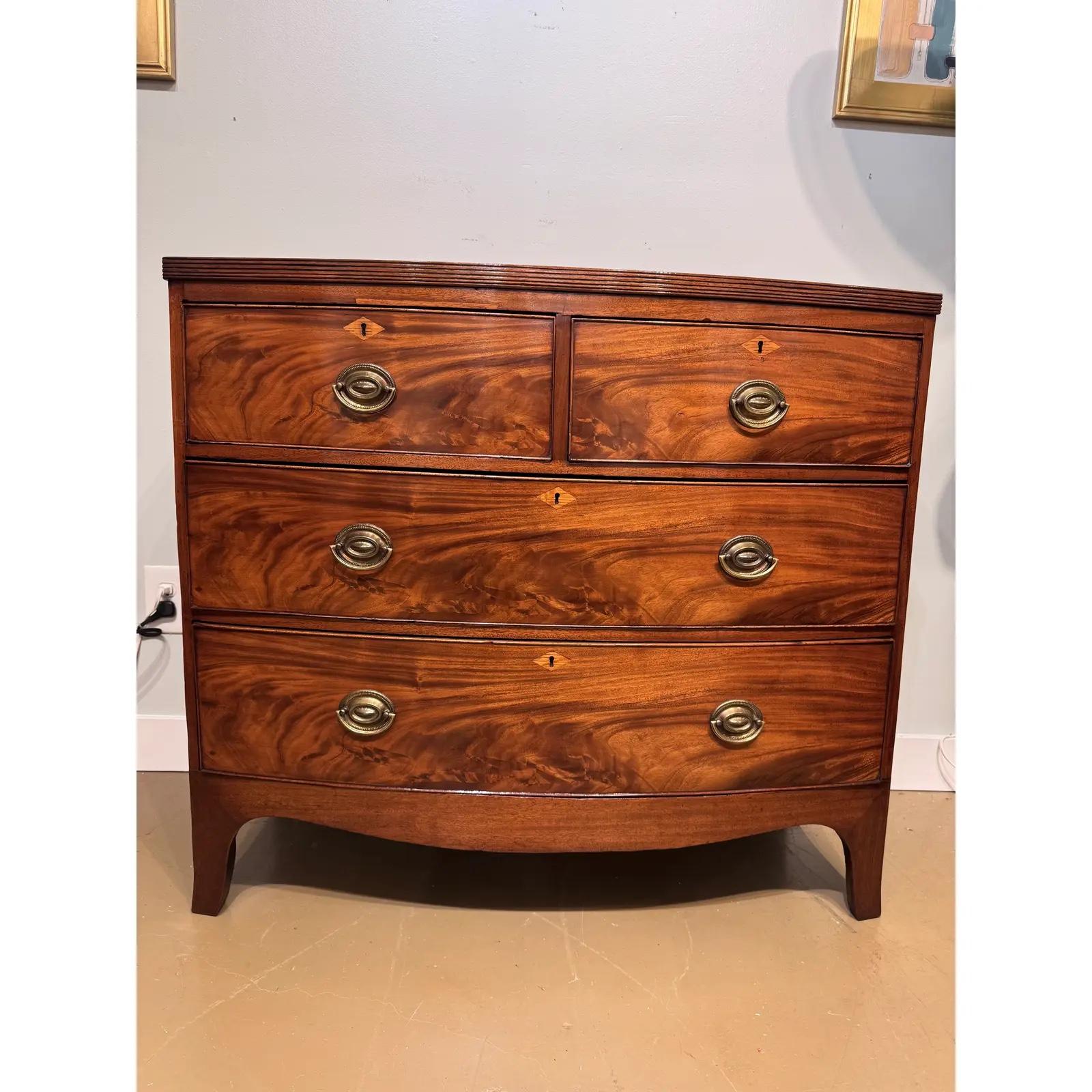 Questa cassettiera inglese del XIX secolo presenta una sorprendente venatura di mogano con una calda patina francese lucida. Un design 2 su 2 La sua silhouette con arco e i tiranti ad anello in ottone aggiungono un fascino classico d'epoca.