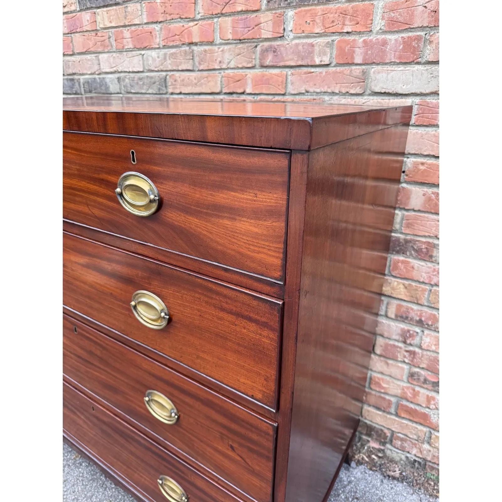 Esta cómoda inglesa del siglo XIX es un mueble bellamente diseñado, con una tapa en forma de caddie, patas cónicas de buen gusto, preciosos frentes de cajón y tiradores Hepplewhite de latón vintage.... Presume de excelente artesanía y está fabricada