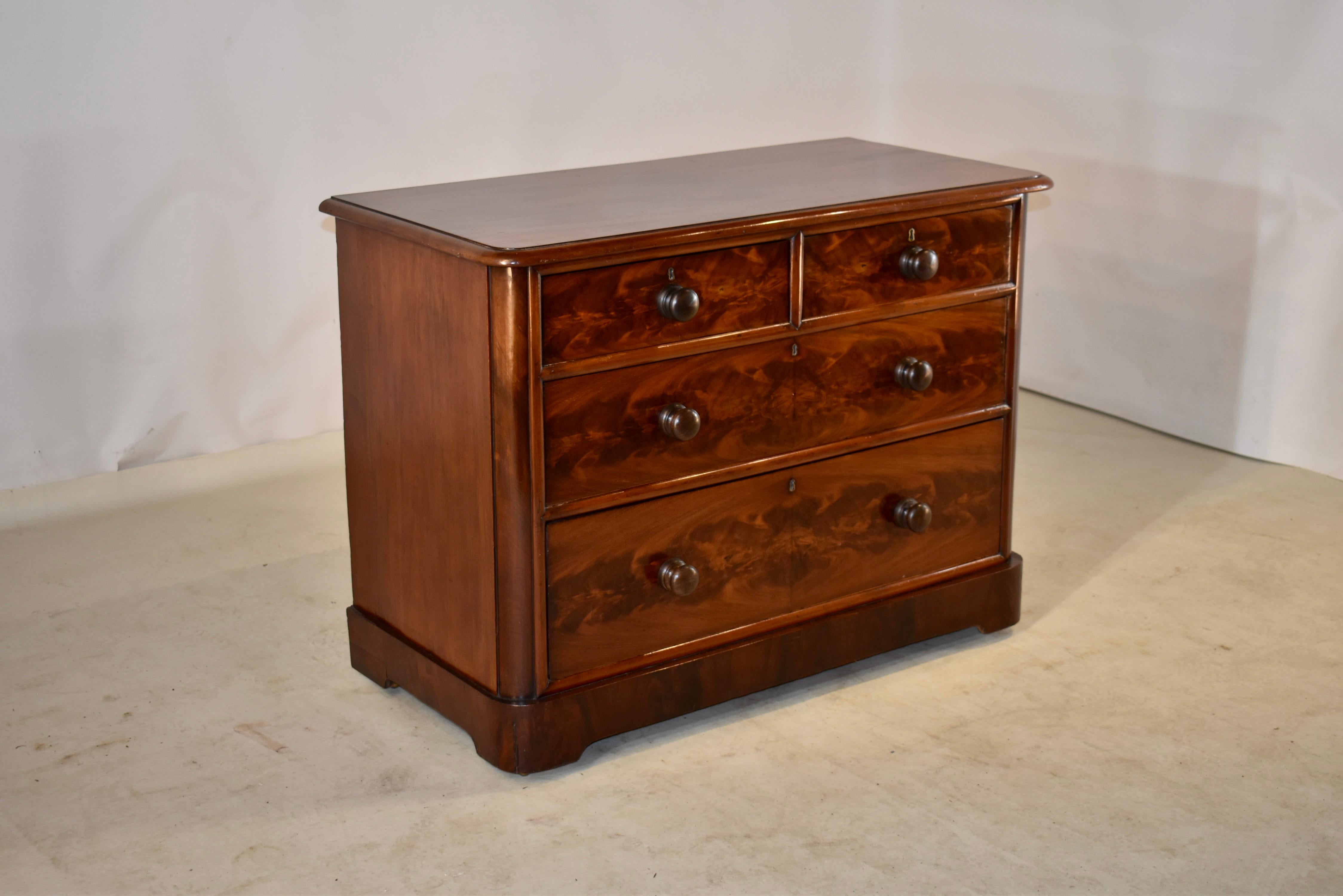 19th century mahogany chest of drawers from England with a single board top with lovely color and graining. This is surrounded by a beveled edge. The sides are simple, and the front contains two drawers over two drawers, all with wonderfully figured
