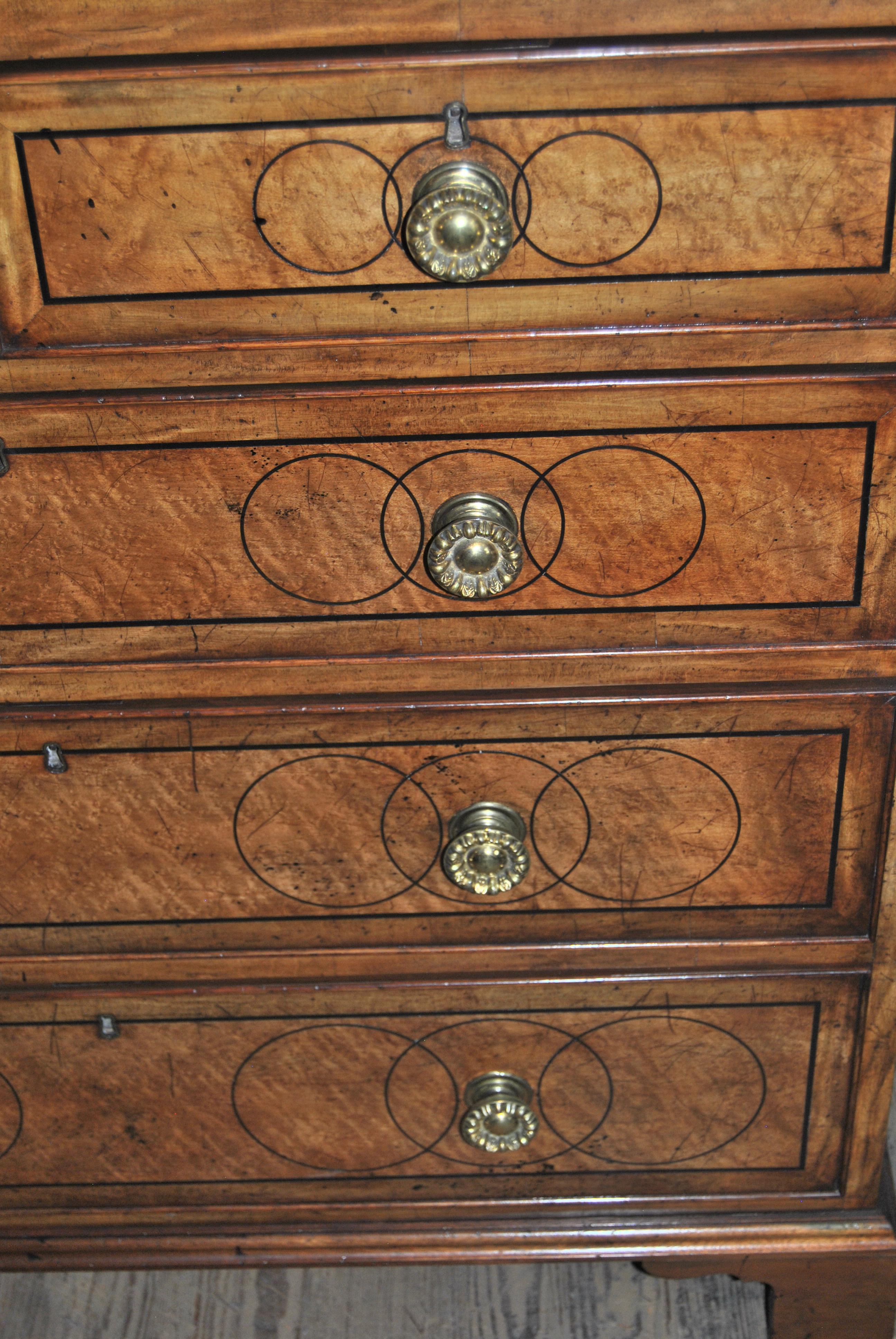 This is a chest of drawers made in England, circa 1830. It is a very beautiful and very unusual combination of woods. The top, all drawer fronts and both the right and left sides are Birds Eye Maple with an ebony string Inlay separating a Satinwood