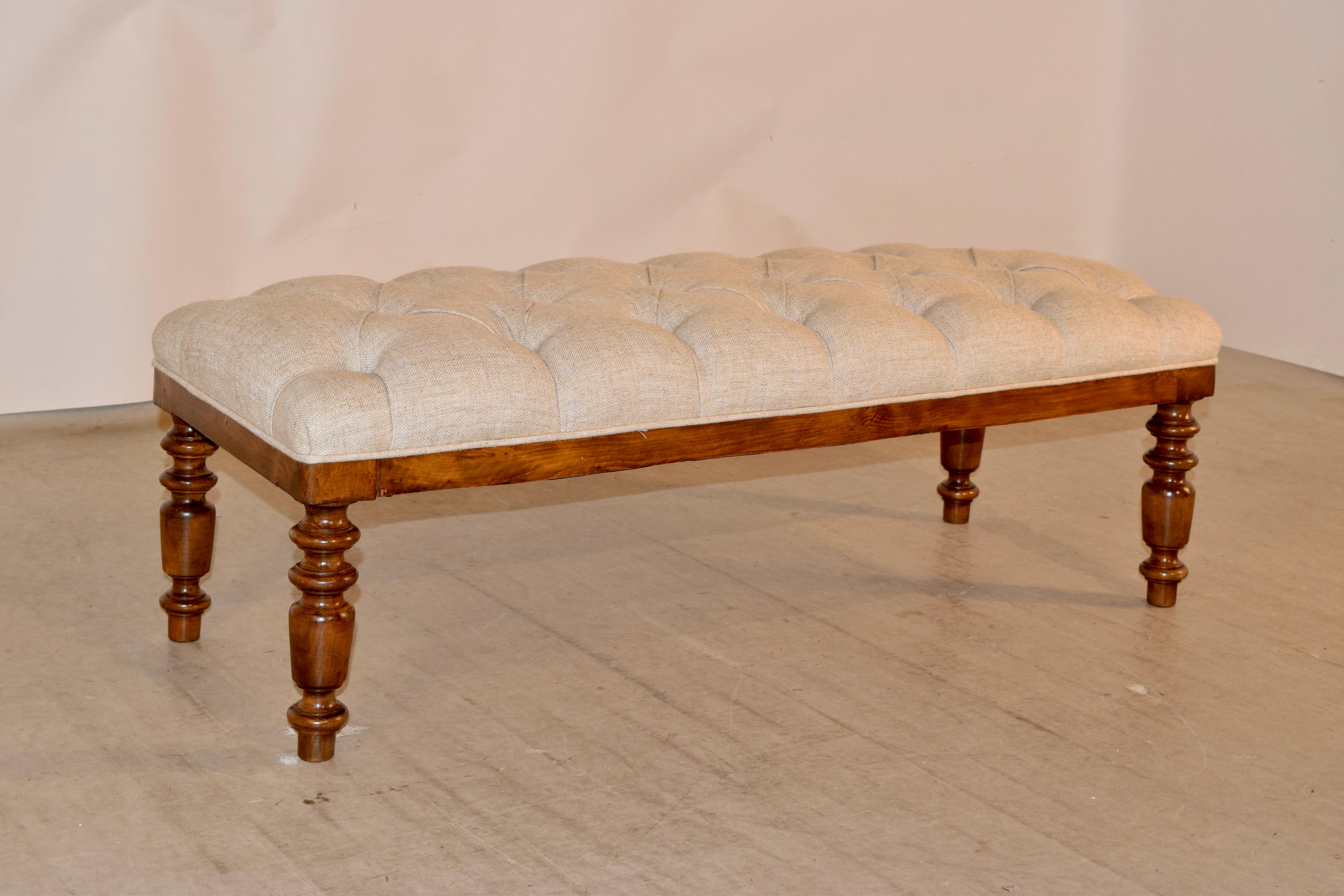 19th century oak bench from England with a Chesterfield style upholstered top in linen. The top has been newly upholstered and tufted in linen and is supported on a lovely oak frame with hand turned legs.