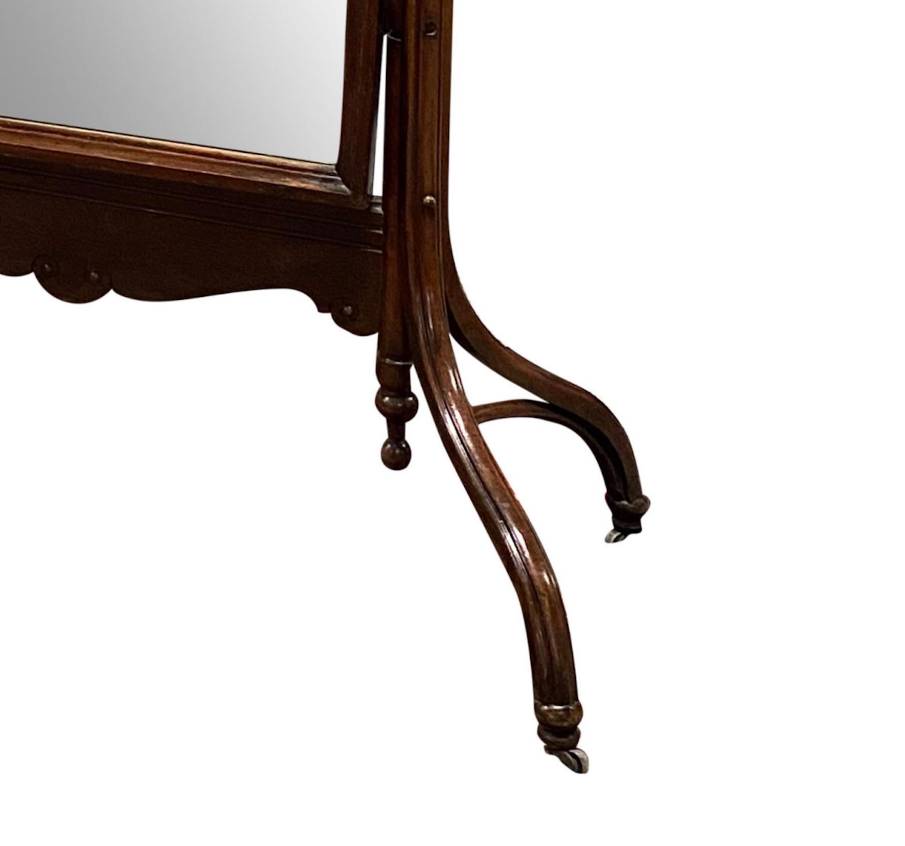 A cheval mirror with rounded top, splaying legs, terminating in brass casters

Made in England

69″ OAH x 49″ OAW x 21″ Deep (4′ x 24.5″W glass)