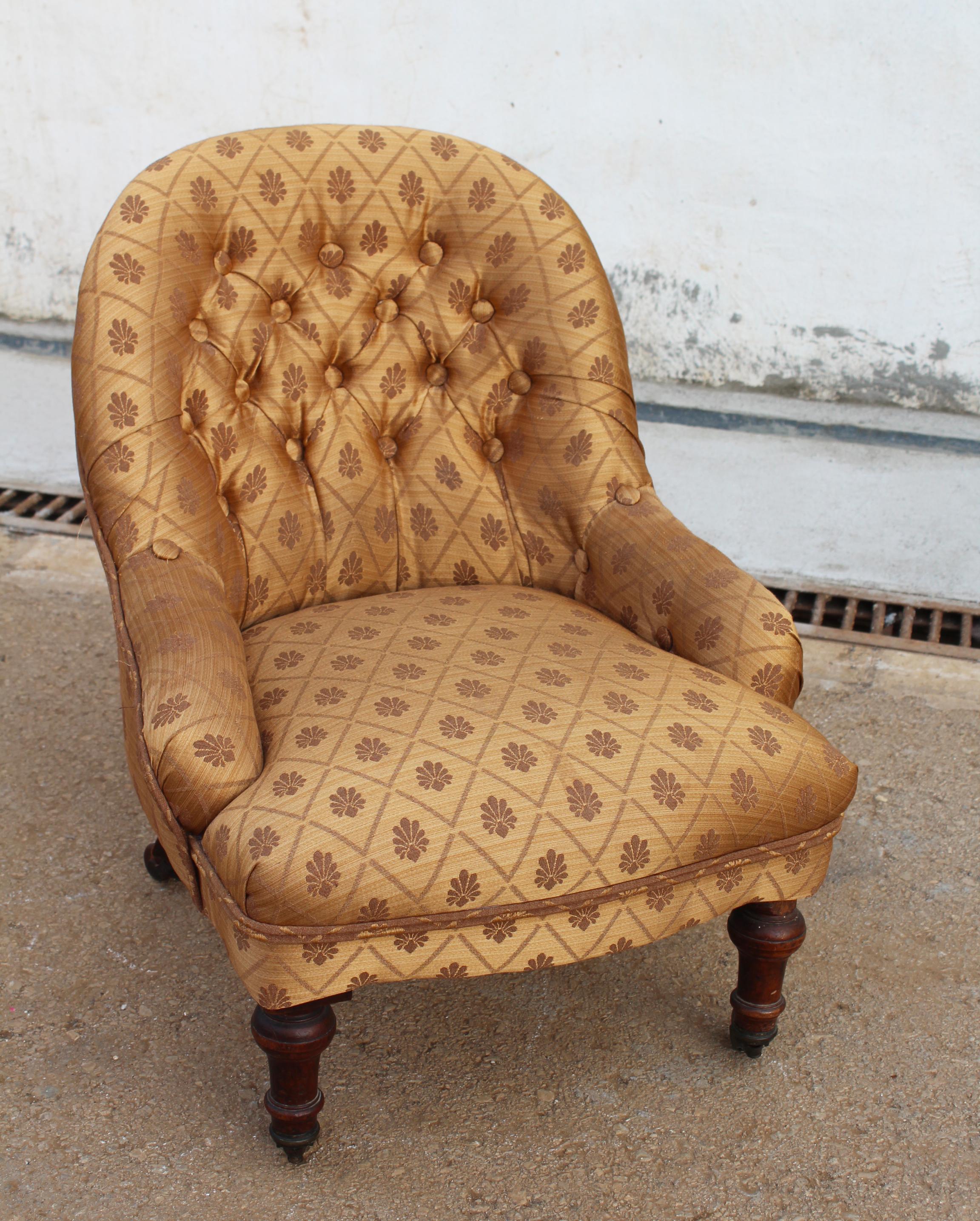 19th century English low children's chair with mahogany legs and natural silk upholstery.