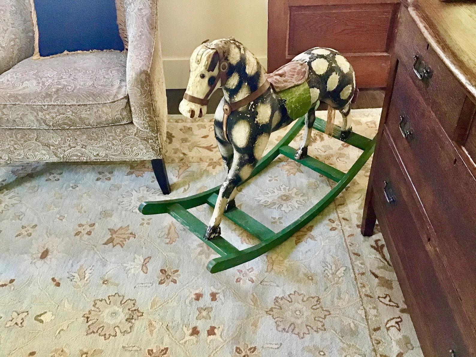 This antique rocking horse is an antique English straw stuffed painted canvas ride on horse.
Some of the paint has been touched up over the long years of use, leather ears are very worn and so is horsehair. It's beautiful primitive piece.


 