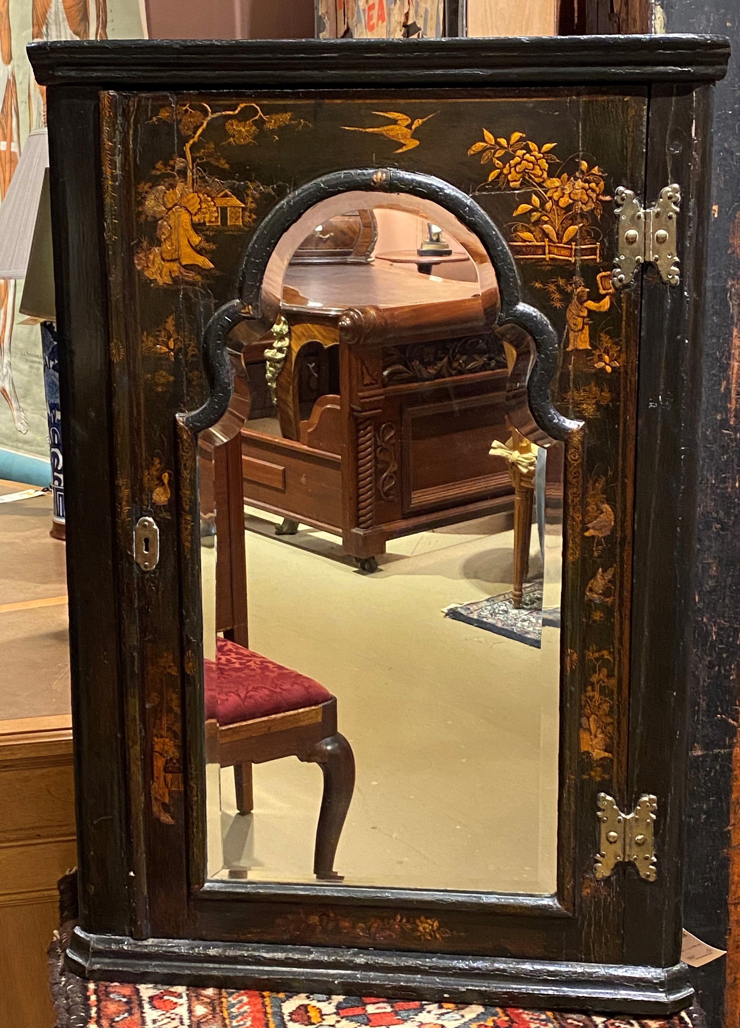 19th century chinoiserie painted and lacquered corner cupboard with mirrored door. Great shaped interior top shelf. Very good overall condition, with some craquelure to the finish, and wear commensurate with age and use. 
