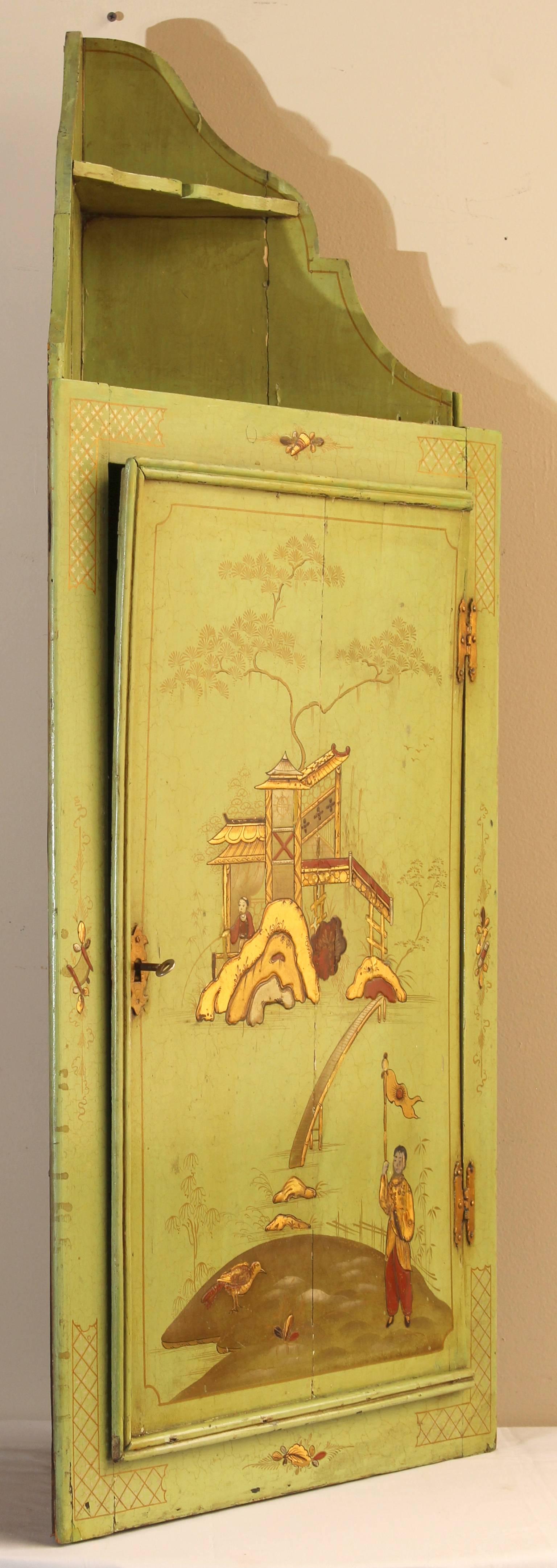 A very charming and unusual apple green chinoiserie decorated mid-19th C English hanging corner cupboard. 