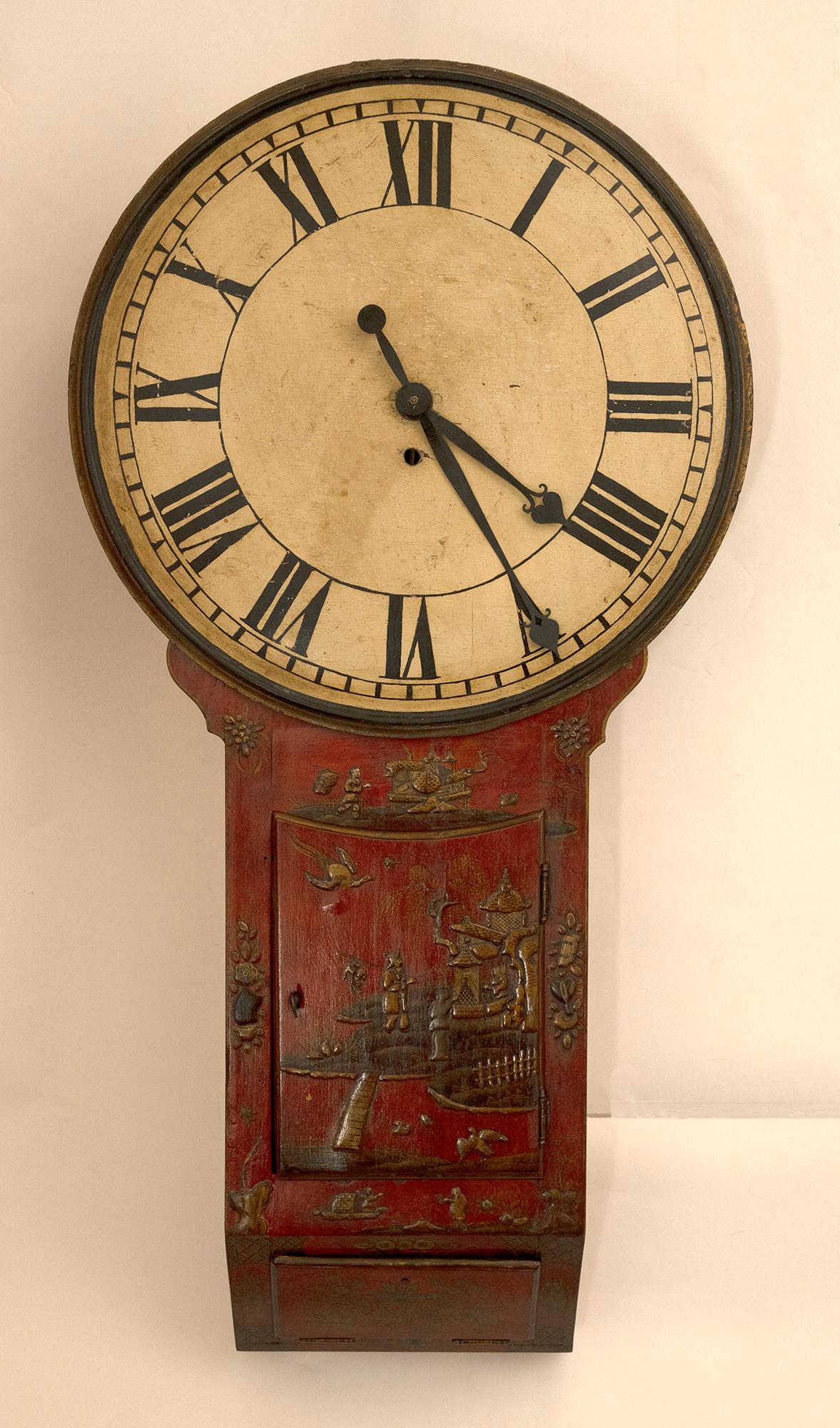 An English Wall Mounted Clock with an oversized dial. The vertical cabinet case having red lacquer finish with raised Chinoiserie decorations circa 1850. Currently not operable. 