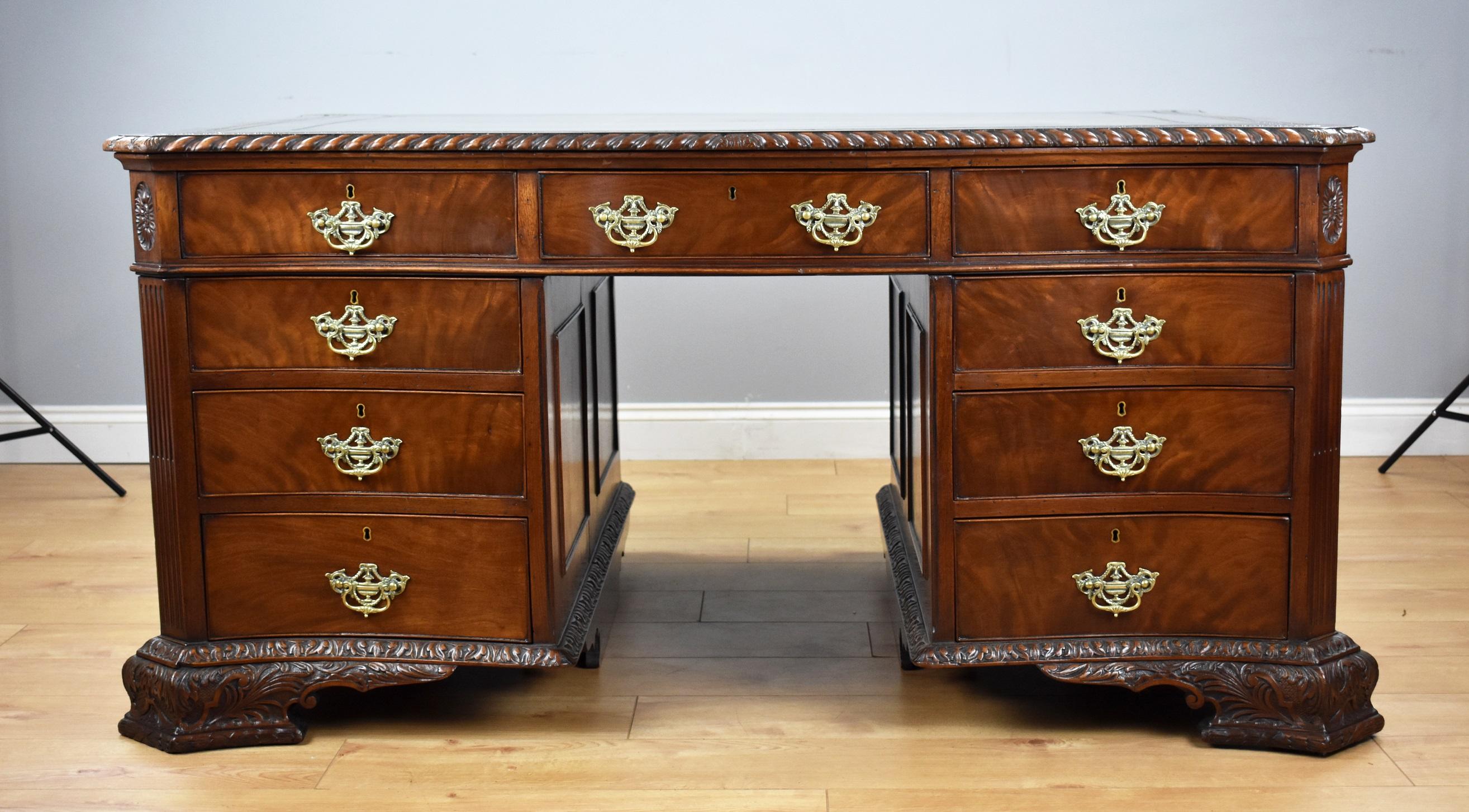 A fine quality antique mahogany Chippendale style serpentine partners desk by S&H Jewell. The top of the desk has a hand dyed green leather hide, decorated with a centre motif as well has fine gold and blind tooling. The top has gadrooned edge,