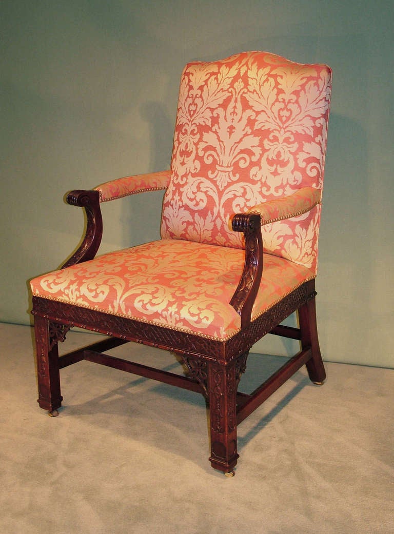 A fine quality mid-19th century Chippendale style mahogany Gainsborough armchair, having serpentine back above acanthus leaf and blind fret carved set-back arms supported on fret carved frieze and square legs with pierced corner brackets with square