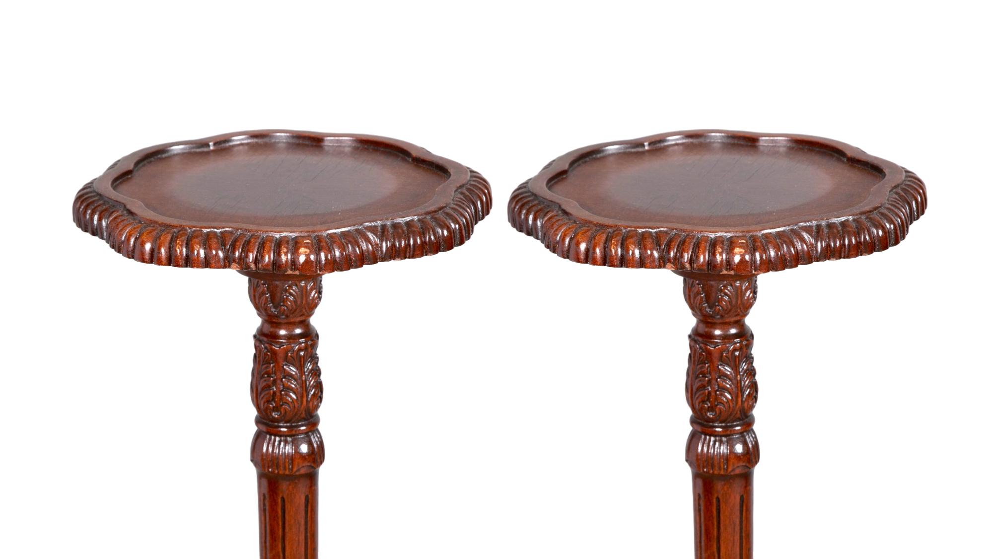 Tauchen Sie Ihren Raum in die zeitlose Eleganz des frühen 19. Jahrhunderts mit diesem exquisiten Paar englischer Mahagoni-Dreibein-Kerzenständer im Chippendale-Stil. Jeder Ständer ist ein Meisterwerk der Handwerkskunst, mit einer handgeschnitzten