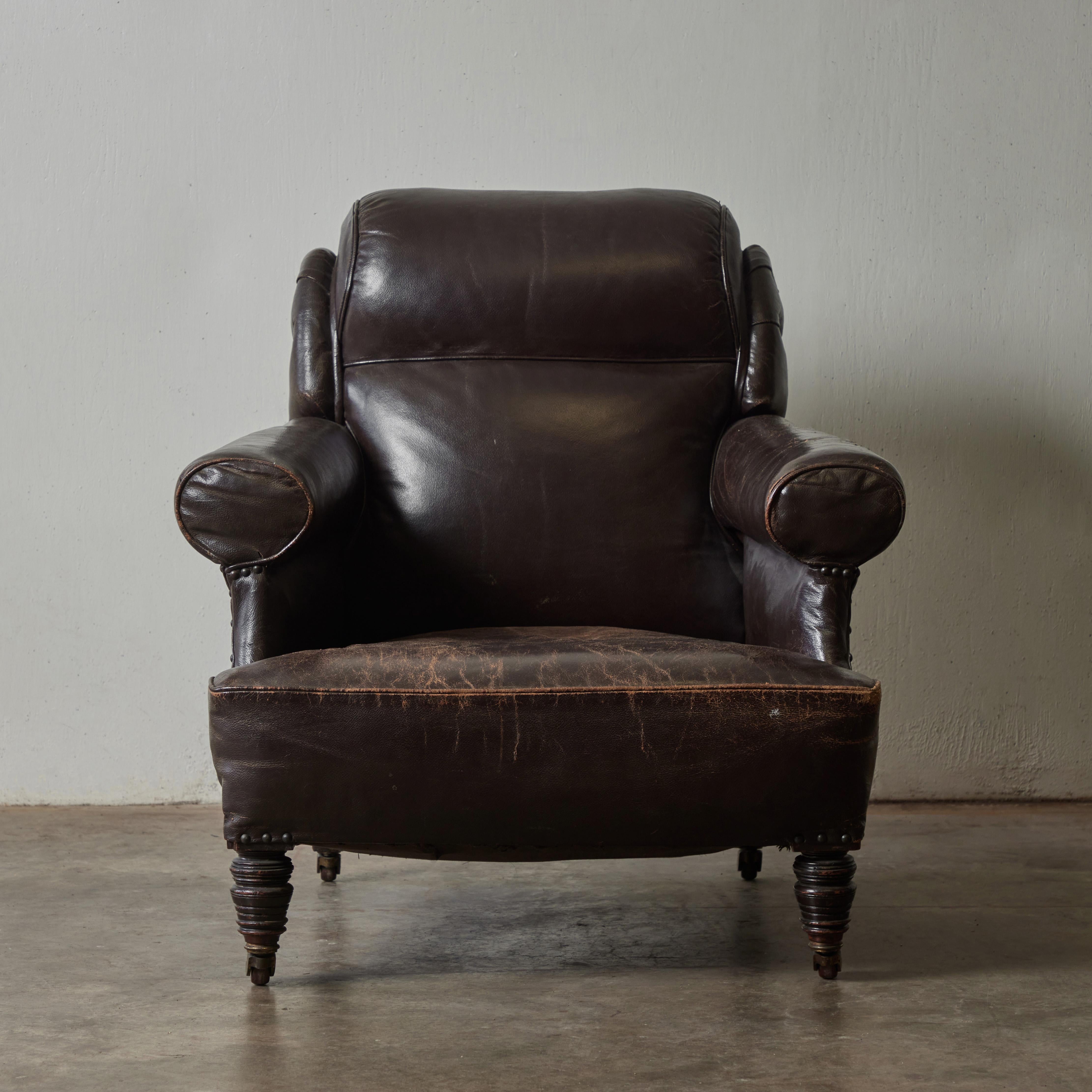 Early 19th-century English leather club chair with carved wooden feet set on casters. The rich chocolate upholstery has a wonderfully soft patina, making this classic piece both comfortable and handsome. 

England, circa 1840

Dimensions: 33W x