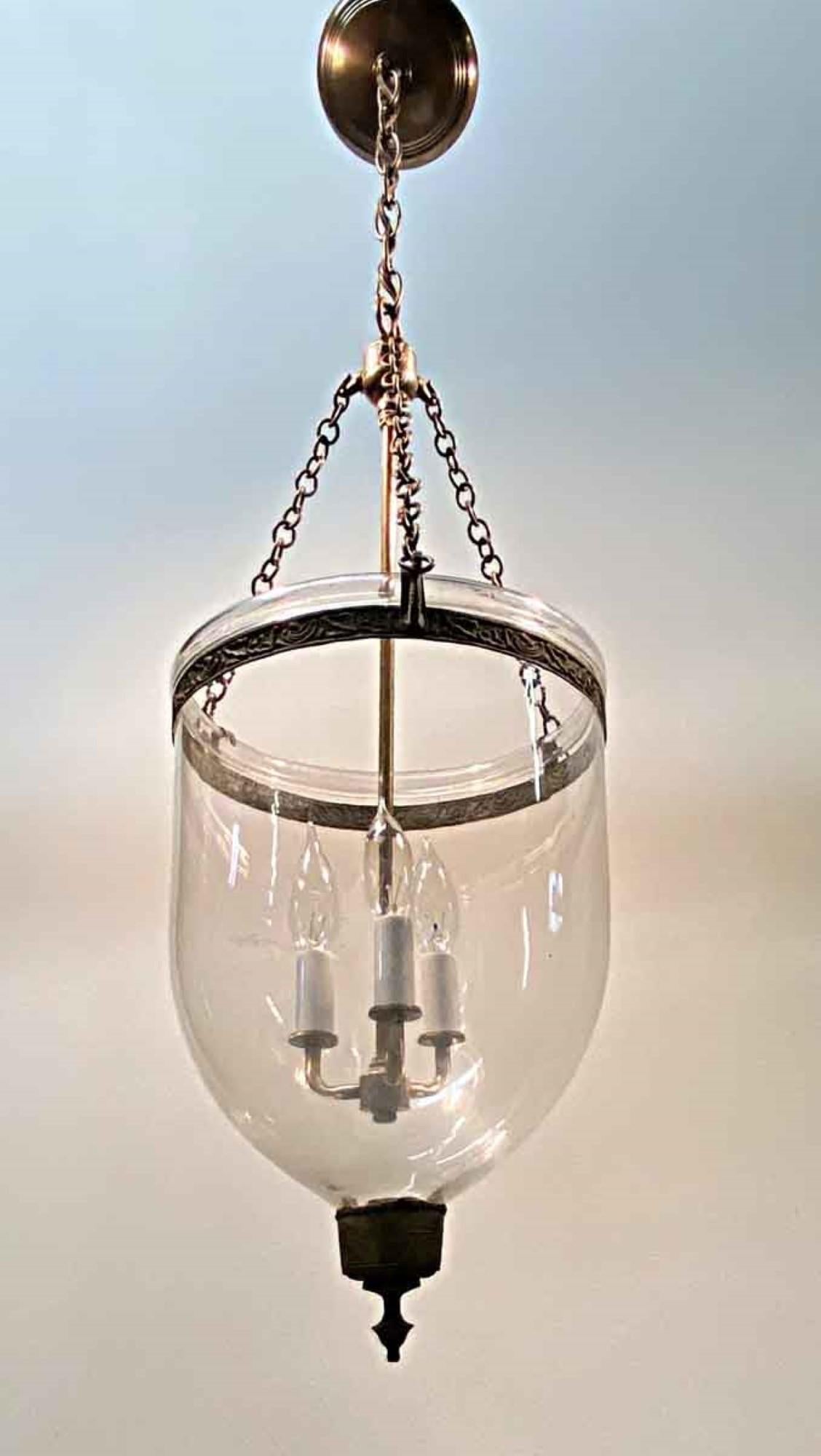 19th century English hand blown bell jar pendant lantern. This glass bell jar has a simple beauty, consisting of clear glass with no etching, and features the original aged patina brass finial and decorative ring around the neck. In the 1800s this