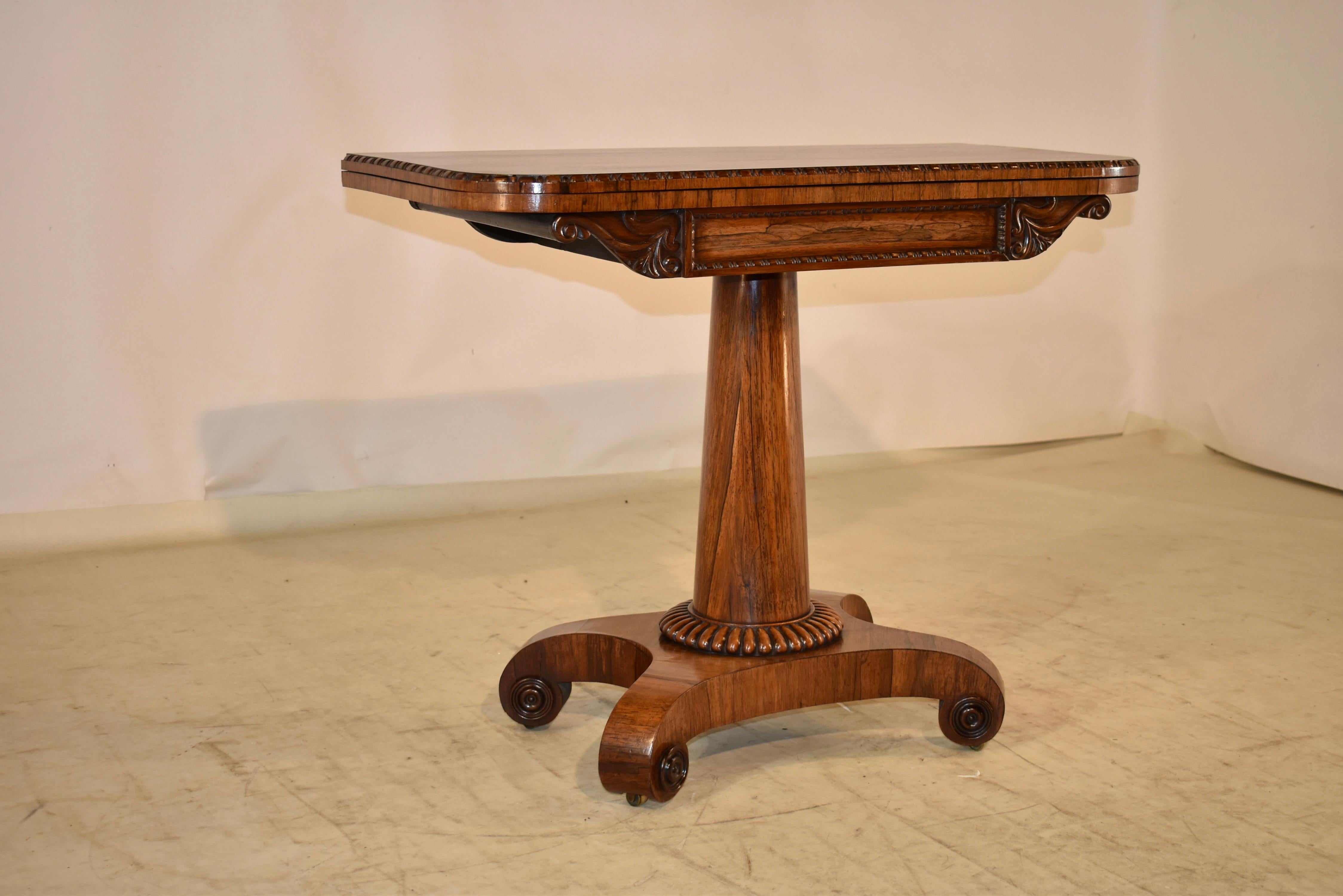 Fabulous 19th century rosewood console or games table from England. The top has elegant graining and a beveled and hand carved decorated edge, and opens to reveal the original felt top games table. The table when opened measures 35.63 inches x 36