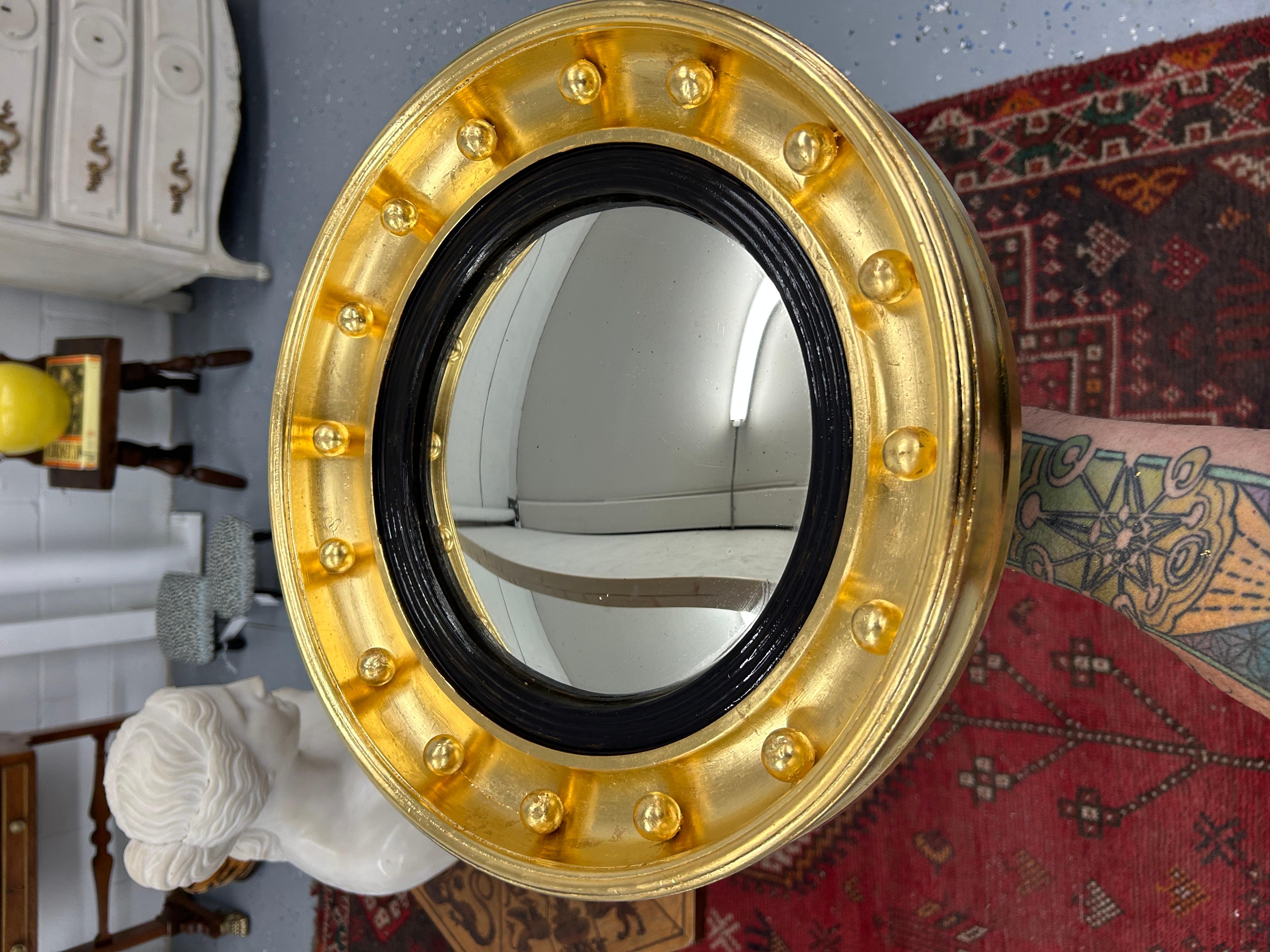 Behold the exquisite beauty of this remarkable 19th Century English Bullseye Convex Mirror, meticulously restored to its former glory and adorned with resplendent gilding of 23k gold leaf. This rare gem of a mirror is a testament to the elegance and