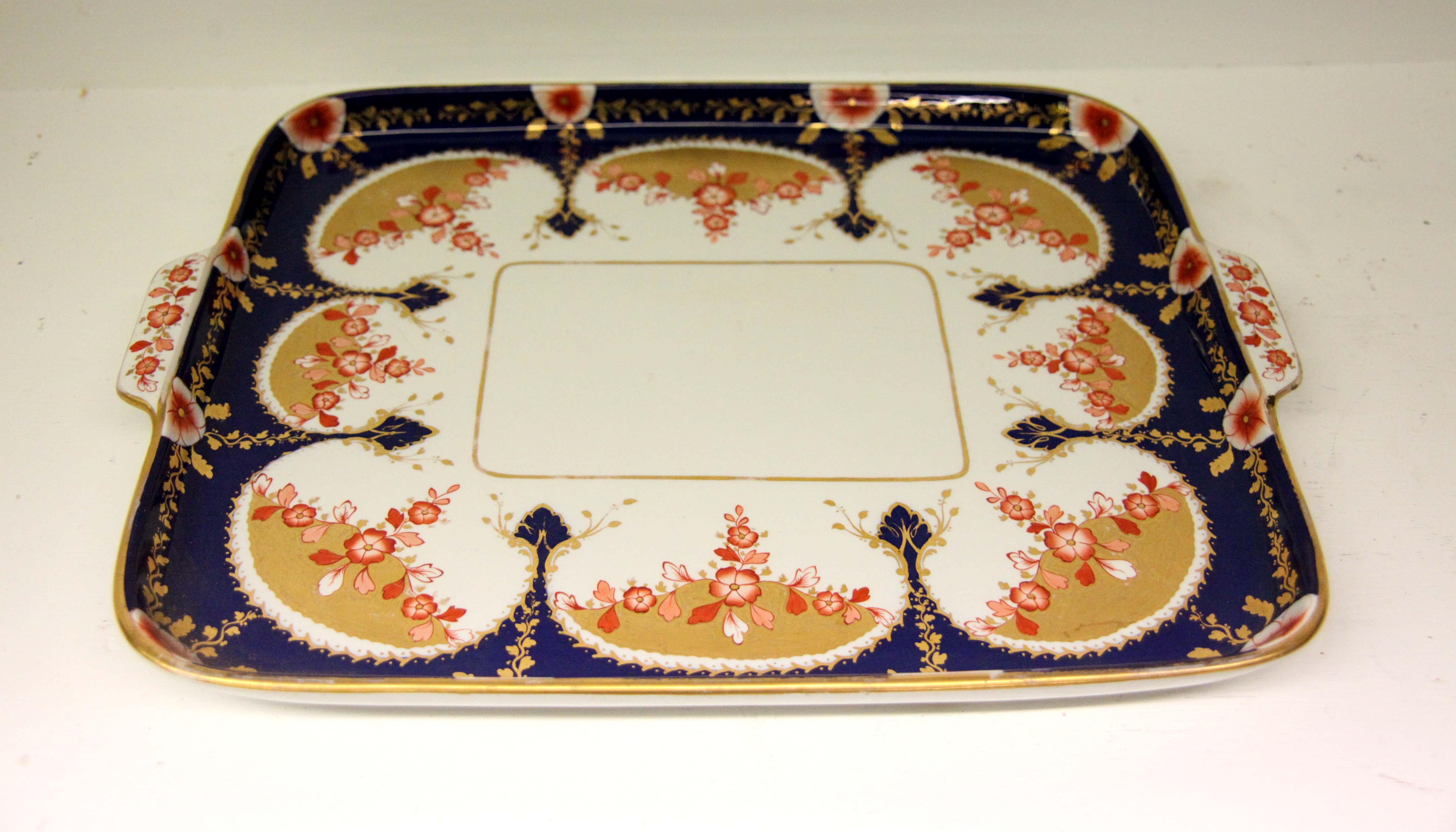 19th century English Copeland porcelain serving tray, the two handled tray with a cobalt border featuring stylized spears adorned with gilt foliate, coral and orange colored flower swags on a gold ground.