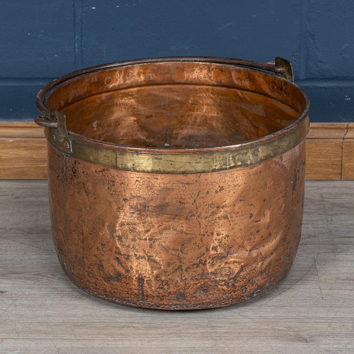 Created around 1860, this substantial copper cooking pot reflects the meticulous attention to detail and skilled artistry characteristic of the era. Its generous size and decorative design make it a striking addition to any kitchen, echoing the