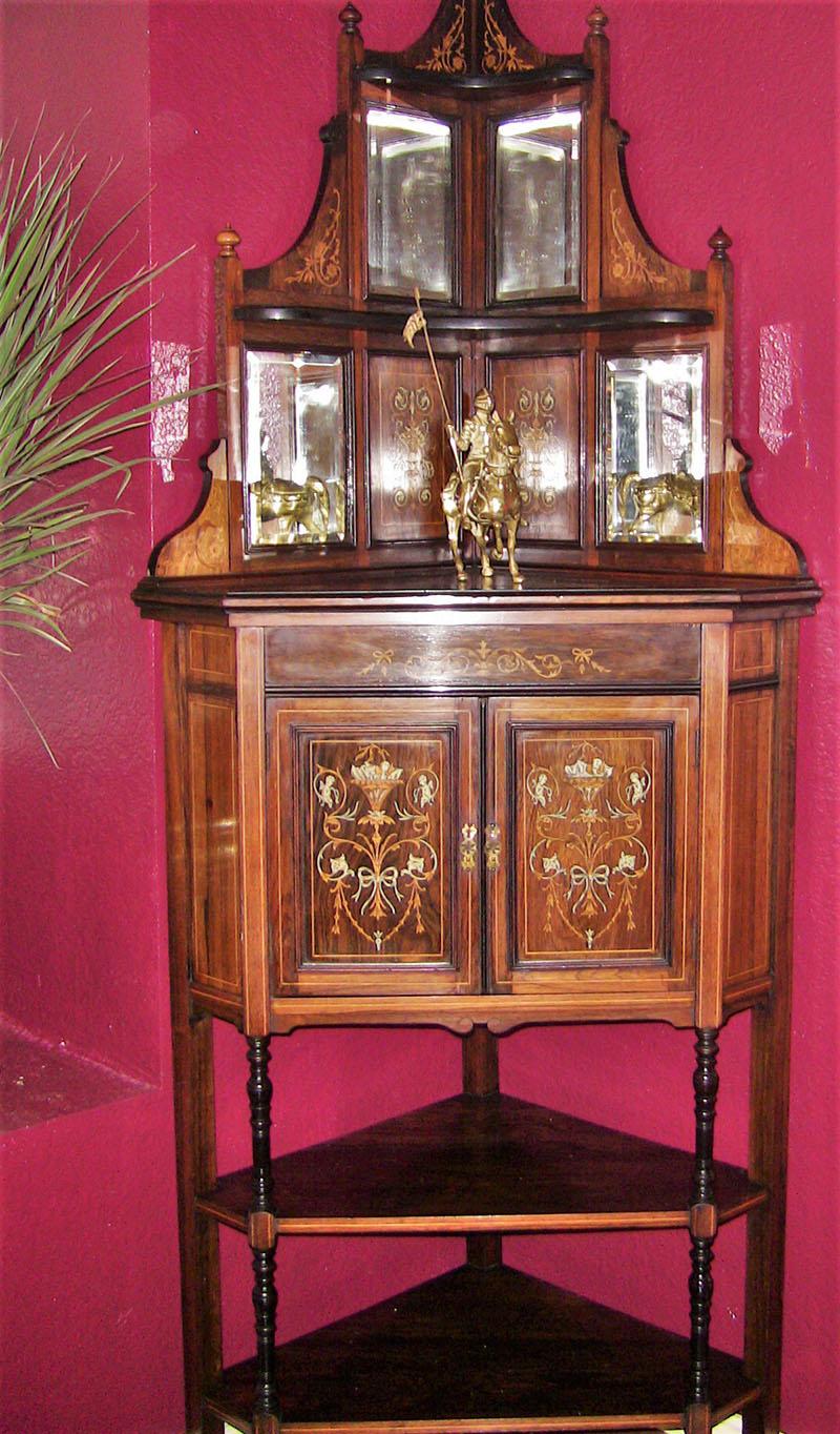 PRESENTING A GORGEOUS late 19th Century British made corner cabinet, made of beautiful rosewood and profusely inlaid with marquetry and faux ivory.

Made in London, by Collinson and Lock, circa 1875-1890.

Triangular/pyramidal in shape, with