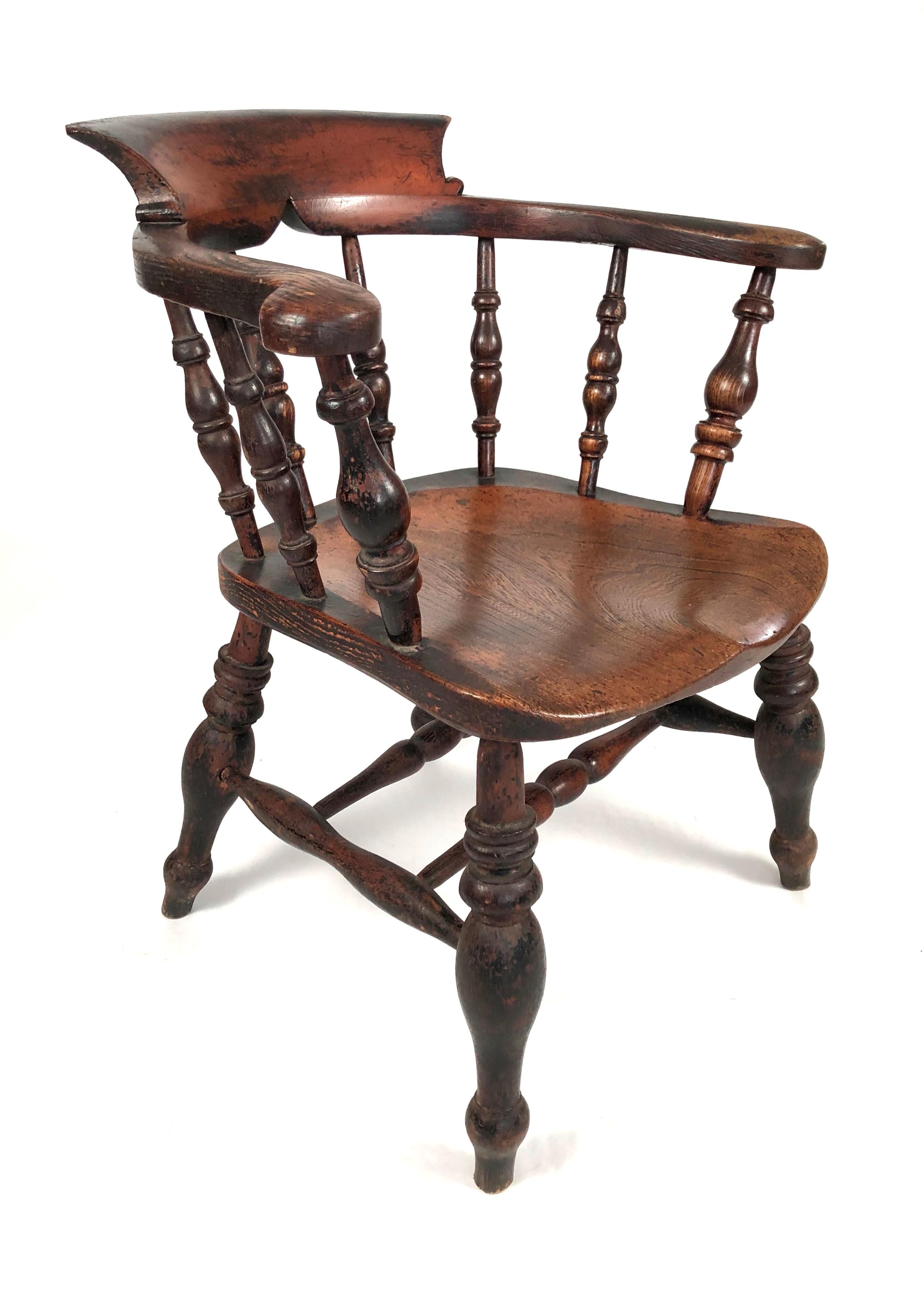 A wonderfully bold 19th century English Country captain's chair in oak with curved back, scrolled arms, a shaped seat and turned spindle back supports, legs and stretchers. Wonderful patina and character as well as being roomy and comfortable.