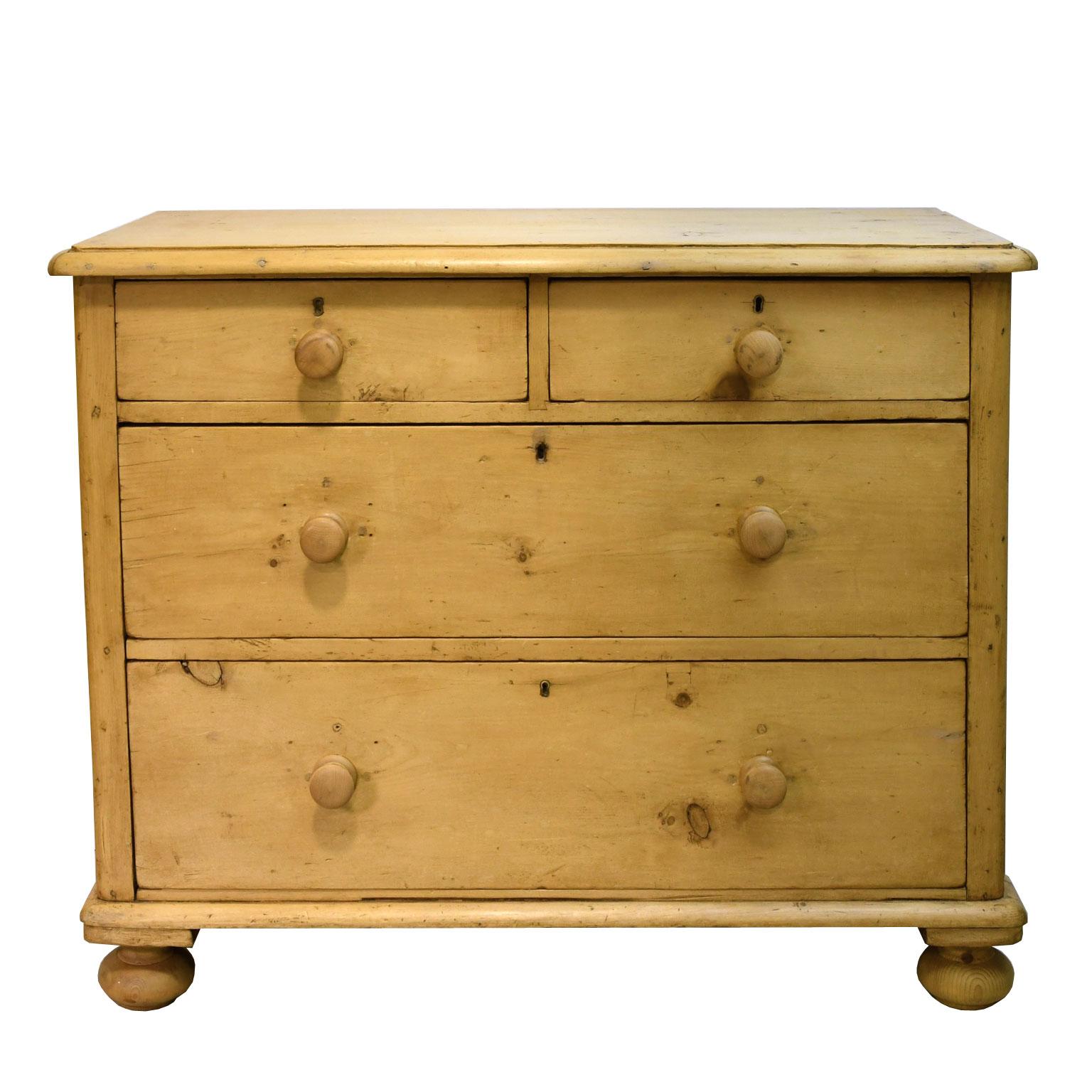A country chest in natural, light-colored pine with two drawers over two larger drawers, all with turned wooden pulls and turned bun feet on the front. England, circa mid-1800s.
Measures: 42