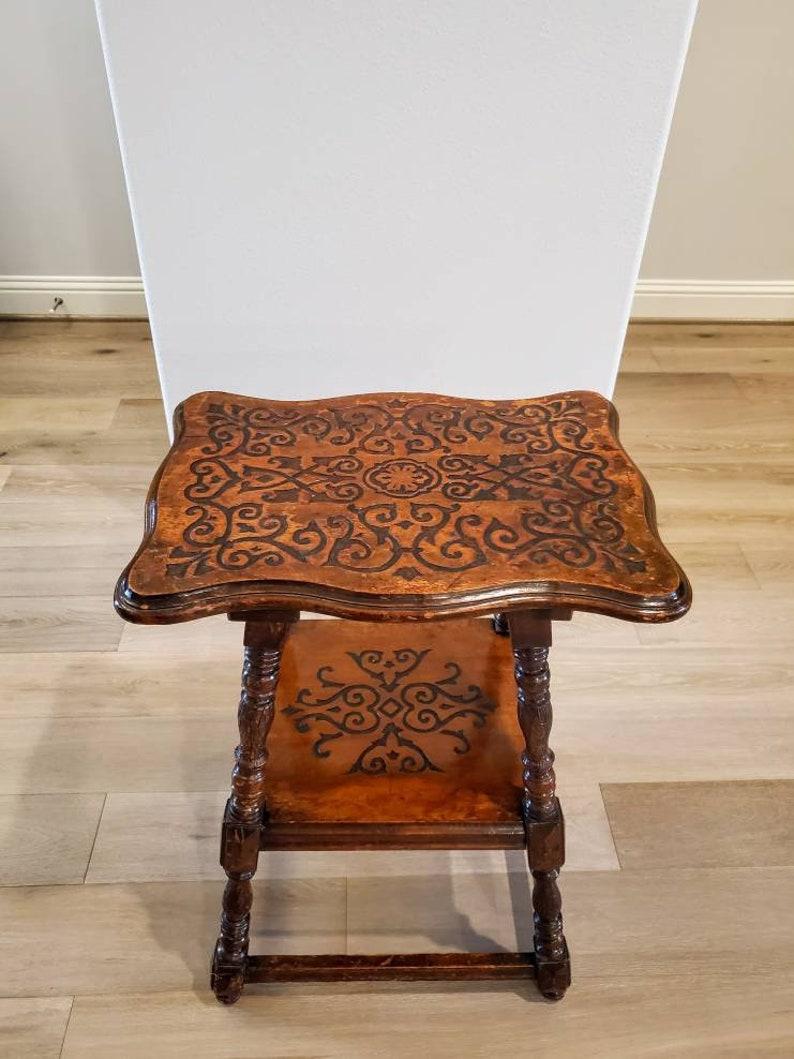 A charming and fine quality antique English oak joint stool style tiered tavern table with nicely aged dark rich warm patina. 

Born in England in the 19th century, hand-crafted, the well made countryside table having a rectangular serpentine shaped