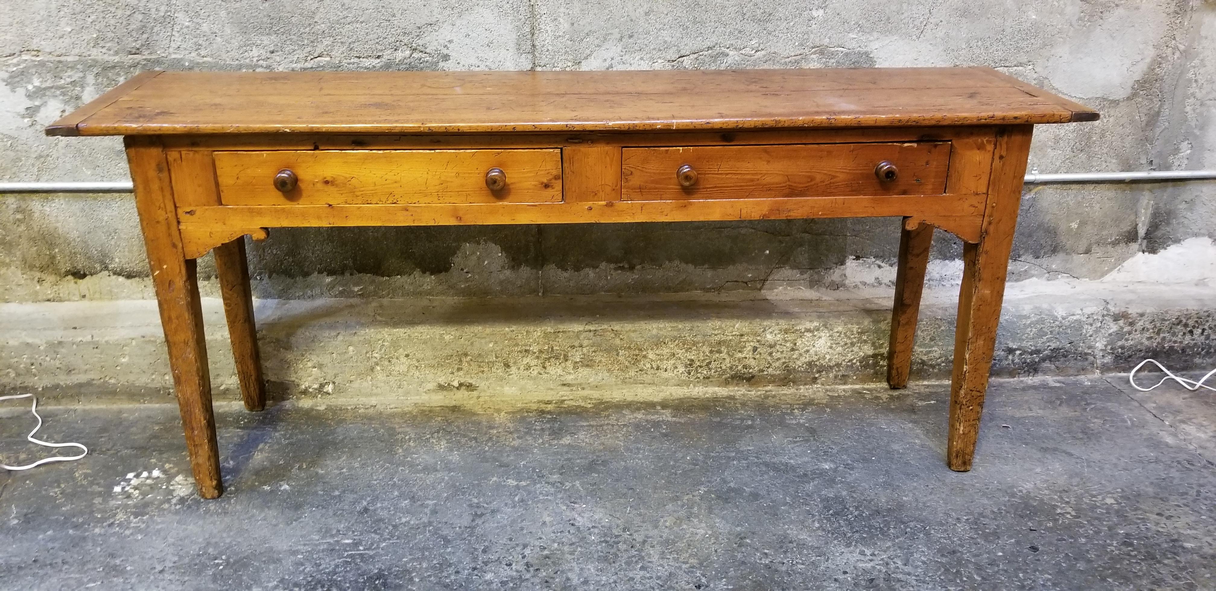 Beautiful rustic and warm patina that can only be found with decades of use. A structurally solid and sturdy 19th century English pine console, hall or sofa back table. Tapered lags, scroll corbels at front and sides and 2 drawers for storage. Hand