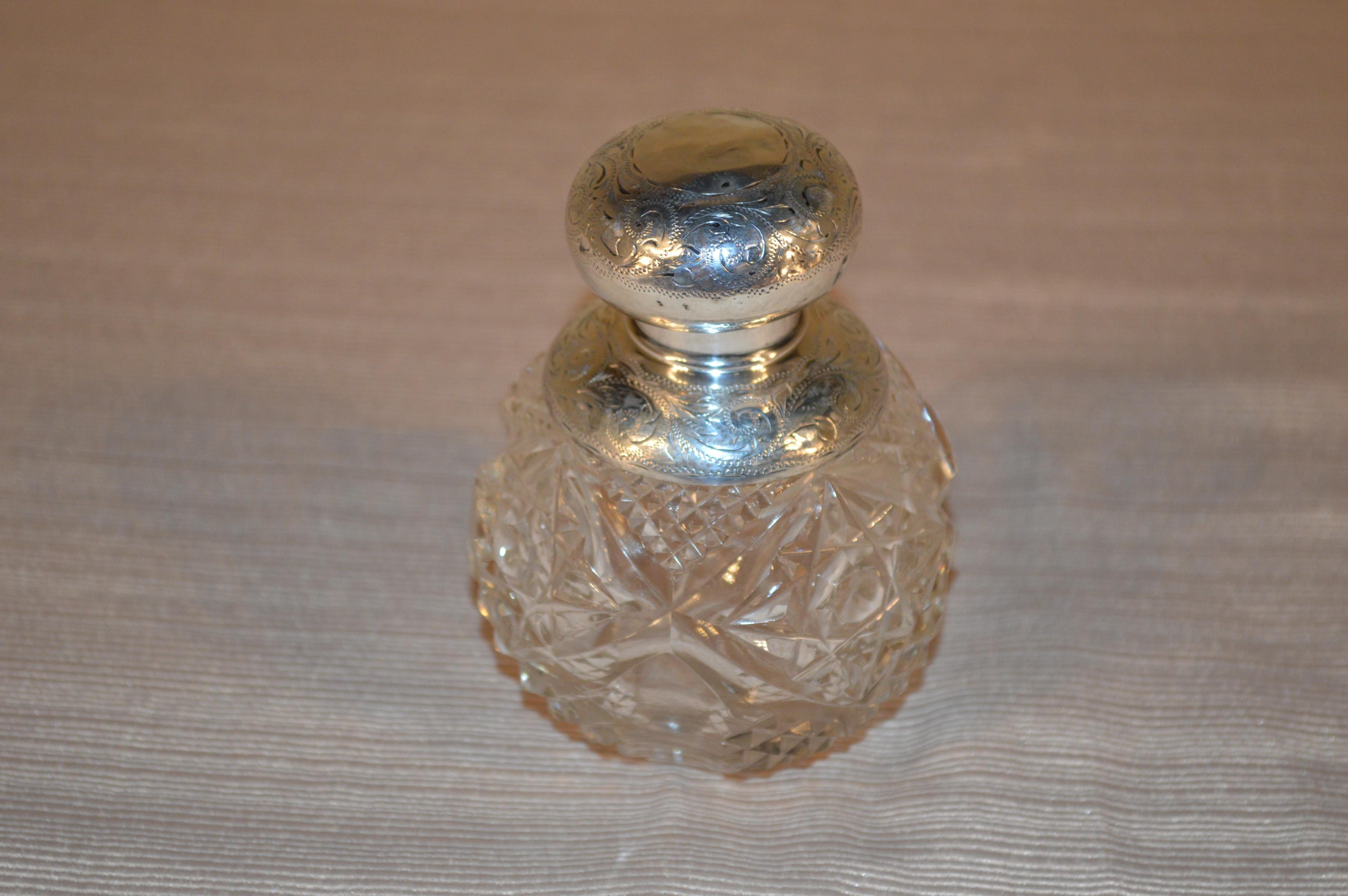 19th Century English cut crystal perfume bottle with stopper and sterling-silver top. The sterling collar is hallmarked but is worn to the point of being unidentifiable.
