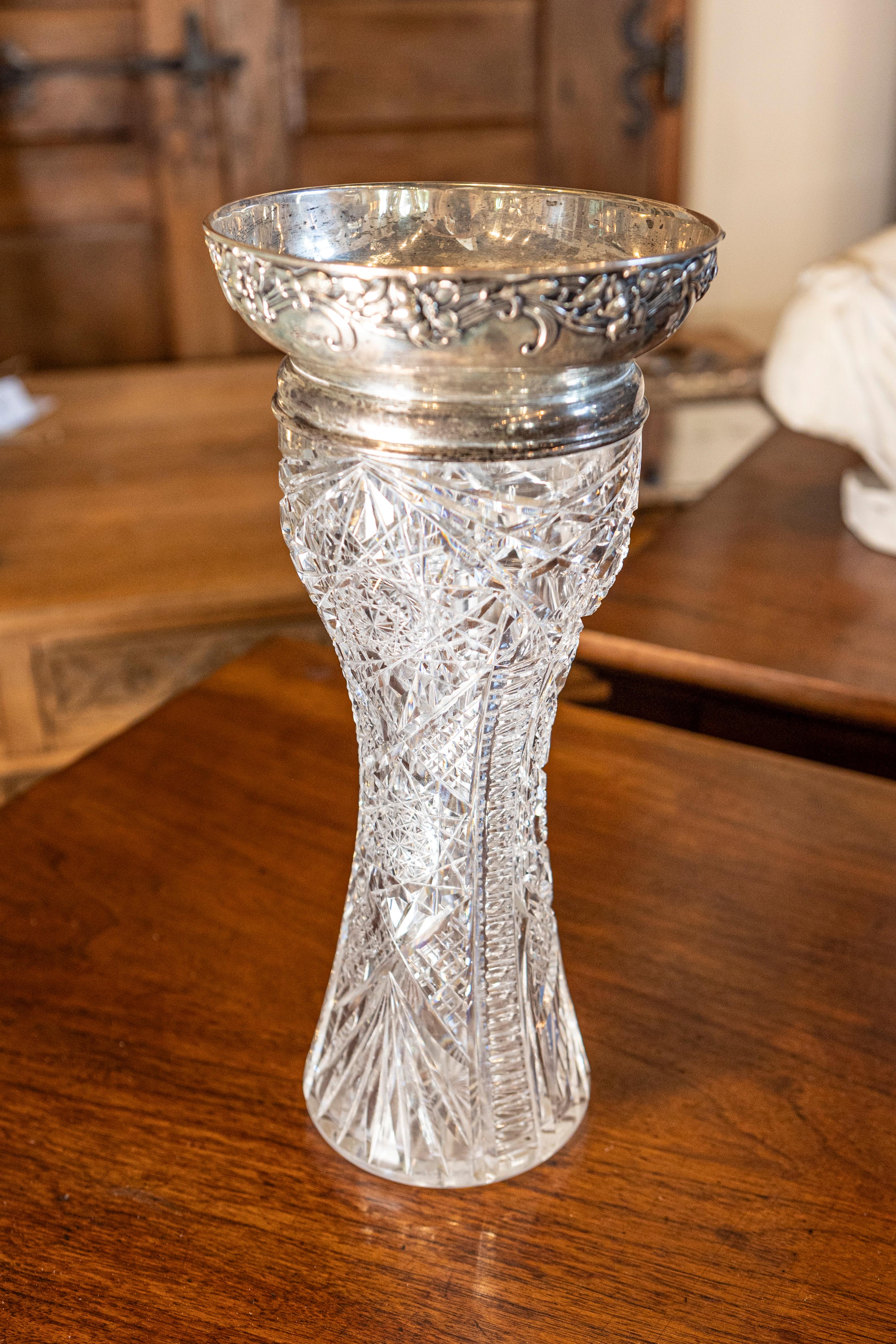 Eine atemberaubende englische Vase aus geschliffenem Kristall aus der späten viktorianischen bis edwardianischen Ära, elegant gekrönt mit einem verzierten Rand aus Sterlingsilber. Dieses wunderschön gearbeitete Stück weist ein tief geschliffenes