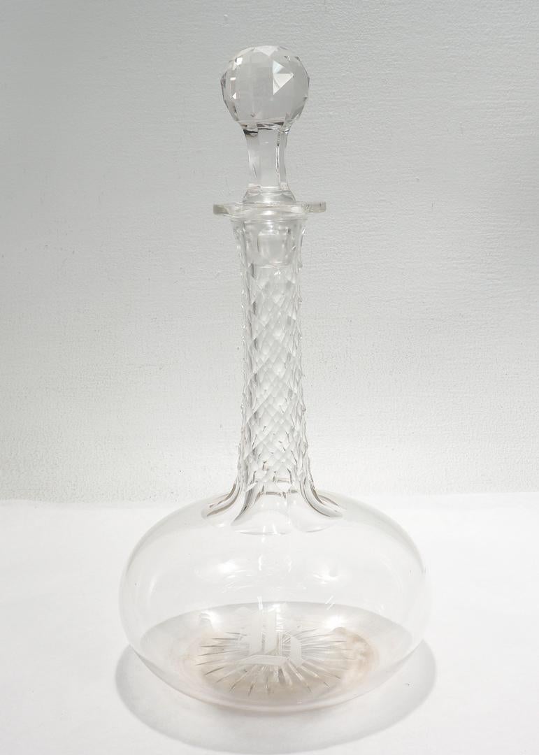 A fine antique English cut glass decanter.

Attributed to F. & C. Osler.

With an elongated neck, diamond cut facets, bulbous bodies, and star cut bases.

Monogrammed to the body with 