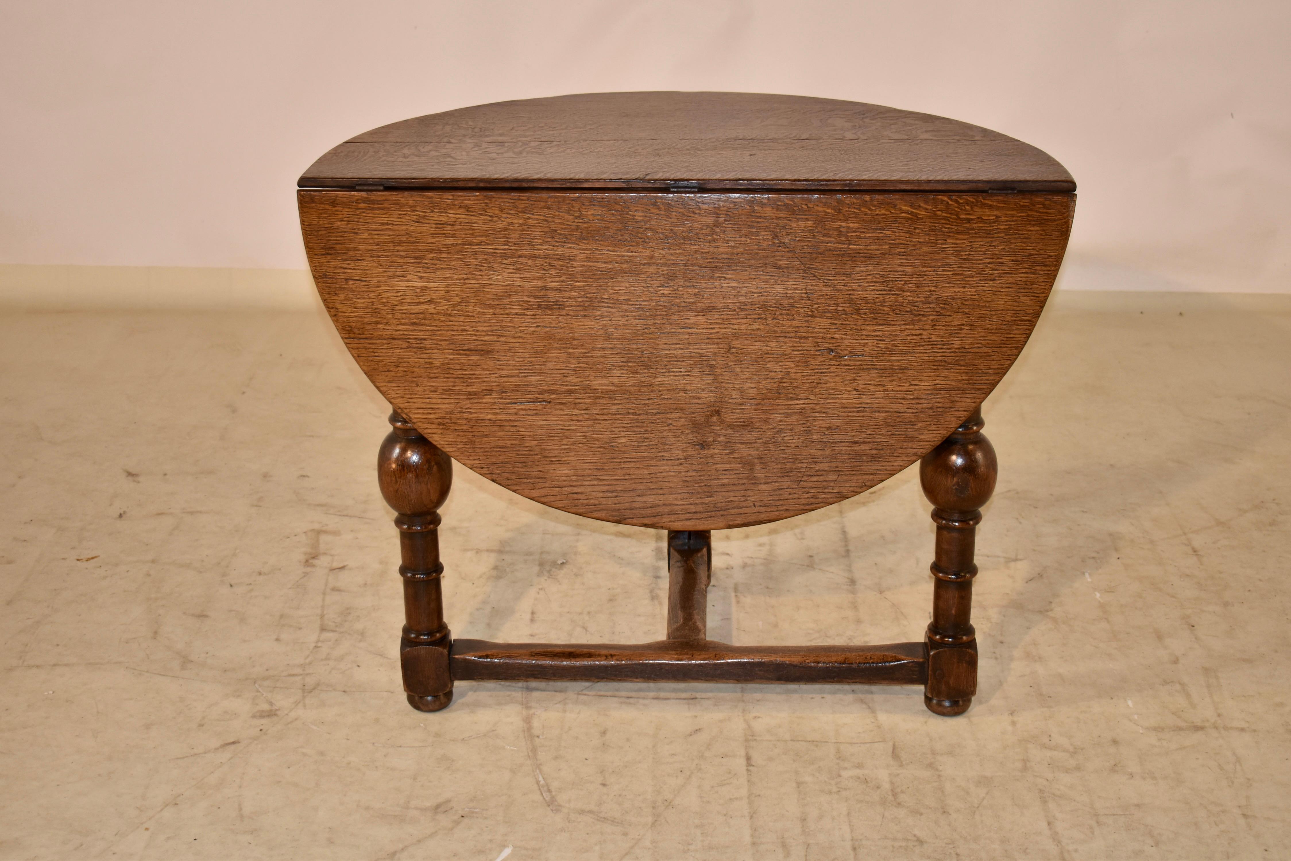 19th century oak Demi-lune drop leaf table from England. The table has wonderful graining in the top, following down to a tripod shaped base, supported on hand turned legs with interesting bulbous turnings and joined by simple chamfered stretchers.