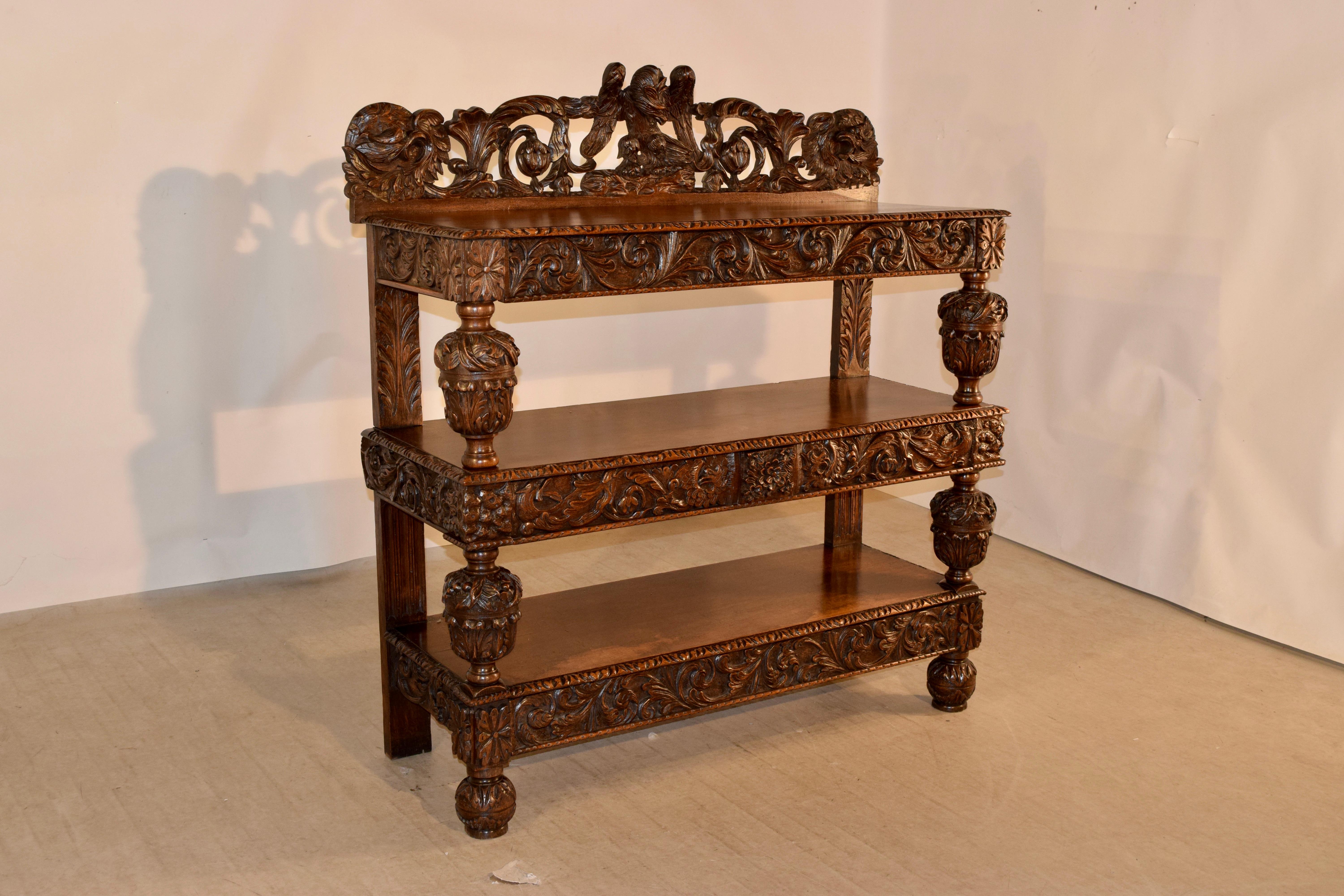 19th century oak dessert buffet from England with wonderfully hand carved decoration. The top has a hand carved and pierced backsplash with a central eagle flanked by florals and fruit, following down to three shelves, all with hand carved and