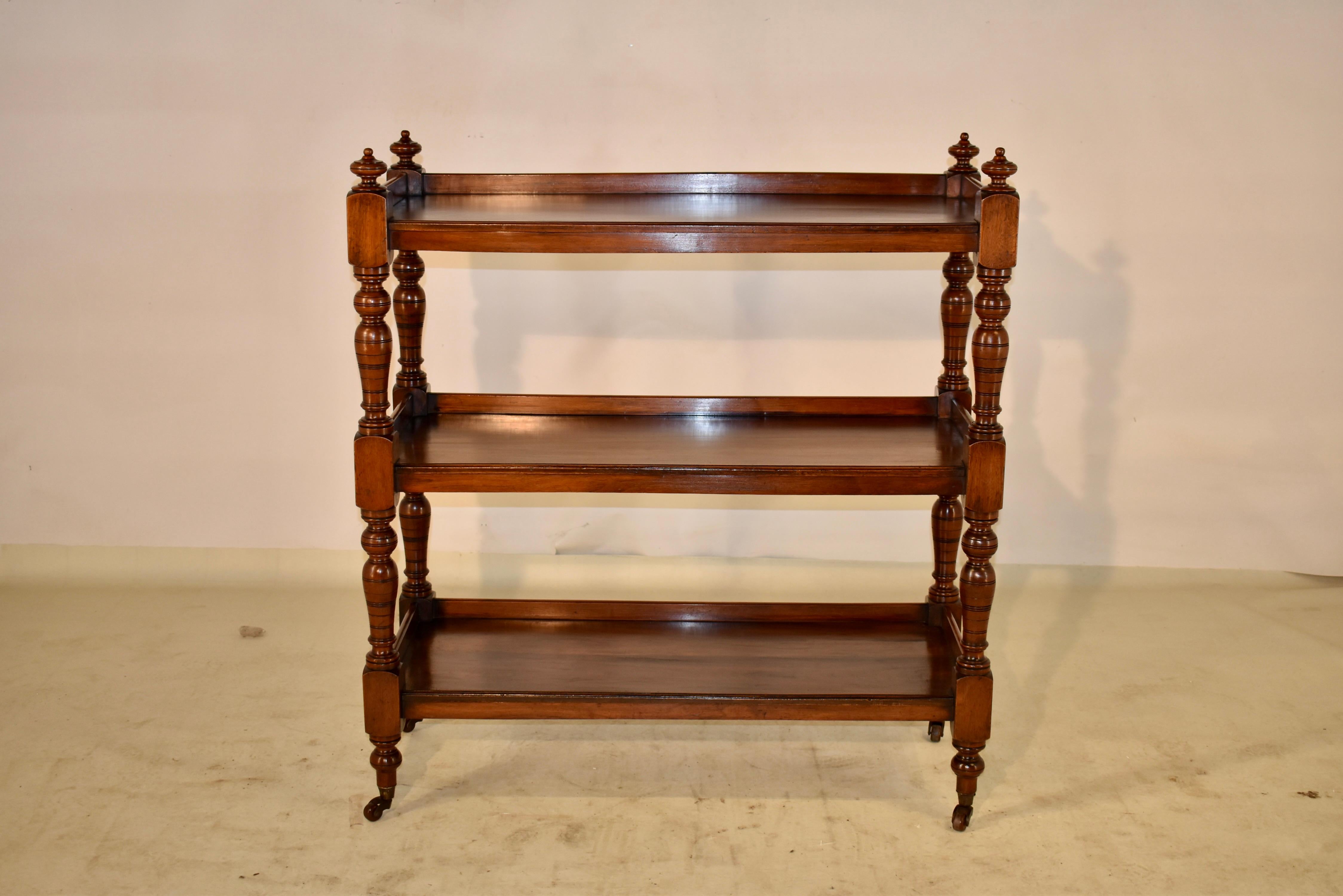 19th Century mahogany dessert buffet from England. The top is decorated with hand turned finials, following down to three shelves, all with galleries. The shelves are separated by hand turned shelf supports, raised on what appear to be the original