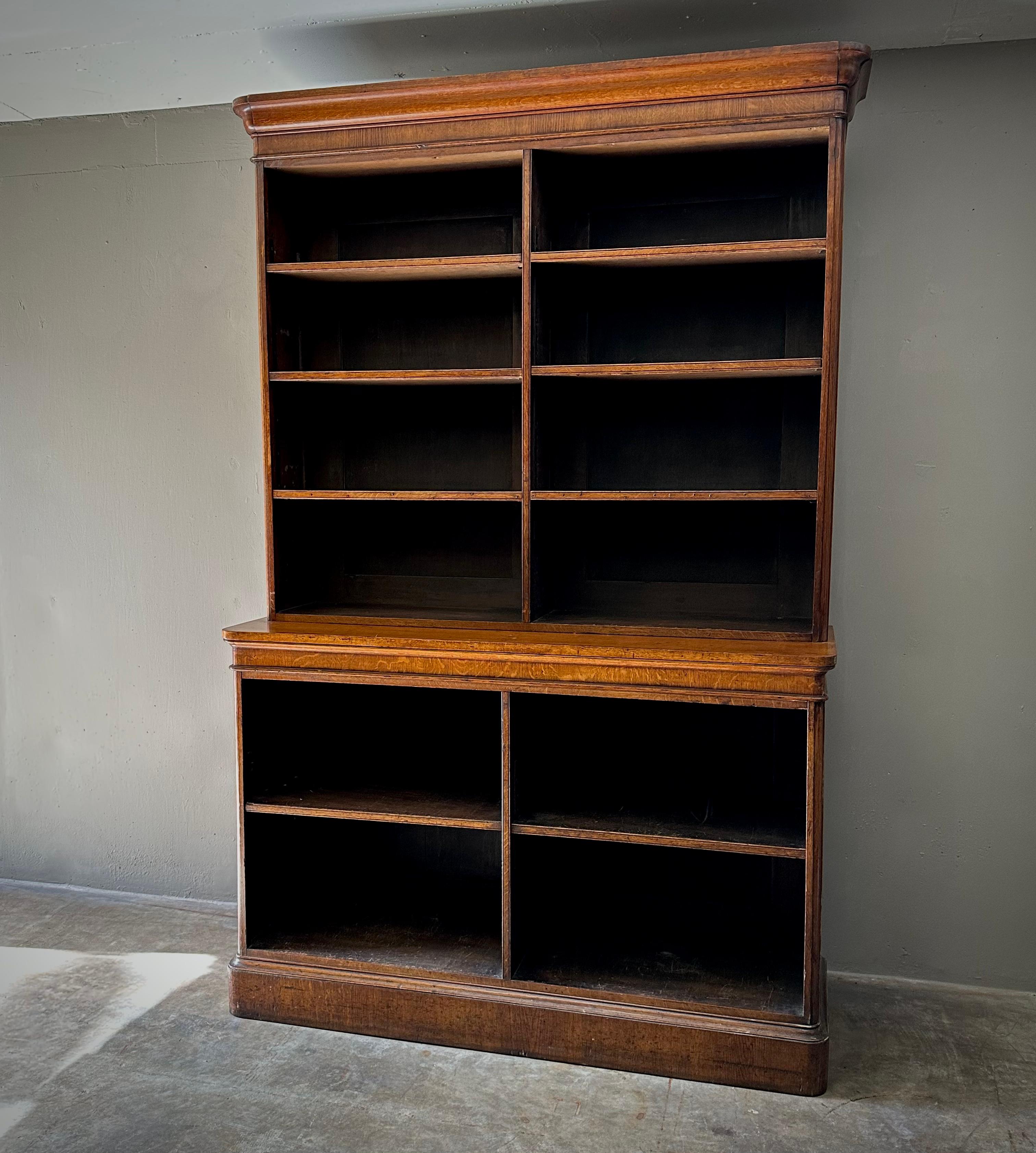 Display bookcase in a nicely aged brown mahogany wood with adjustable shelves. The piece is built in in two parts, and includes an extending shelf surface. The adjustable shelves create ample opportunity for unique display arrangements. 

England,