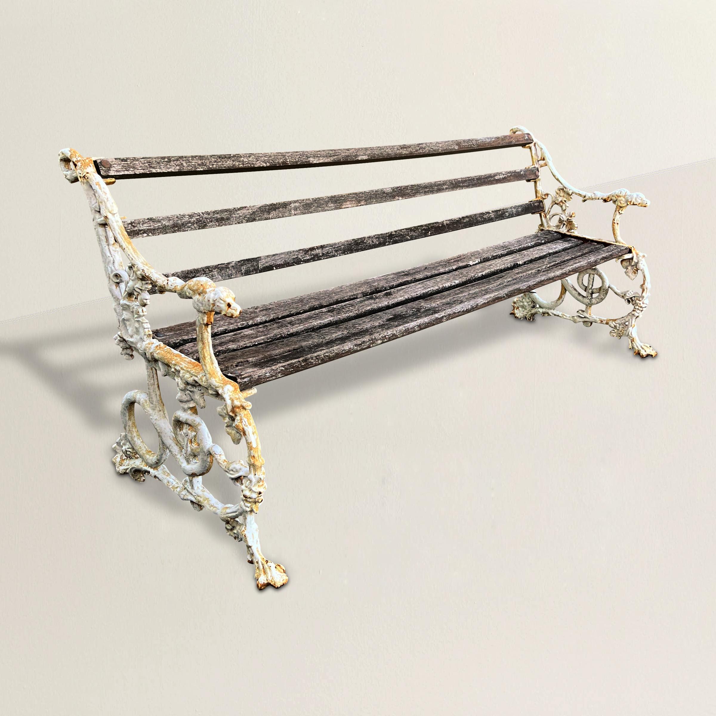 A remarkable classical 19th century English 'Snake and Dog' cast iron garden bench by famed iron forge, Coalbrookdale Iron Company, with dog head arm finials and sides with swirling snakes eating grape clusters. This pattern was an instant classic