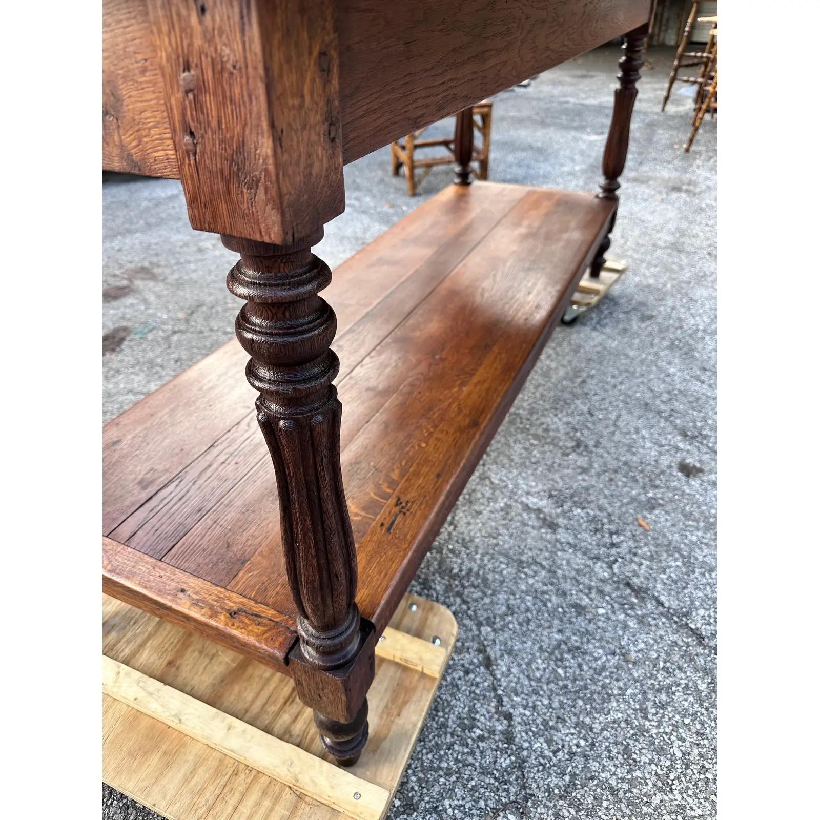 This is a beautiful 19th century two-tiered English table! The wood is dark and glossy, and the reeded legs add the perfect touch of refined elegance. This piece would have been originally used in an English merchant's shop to cut long bolts of