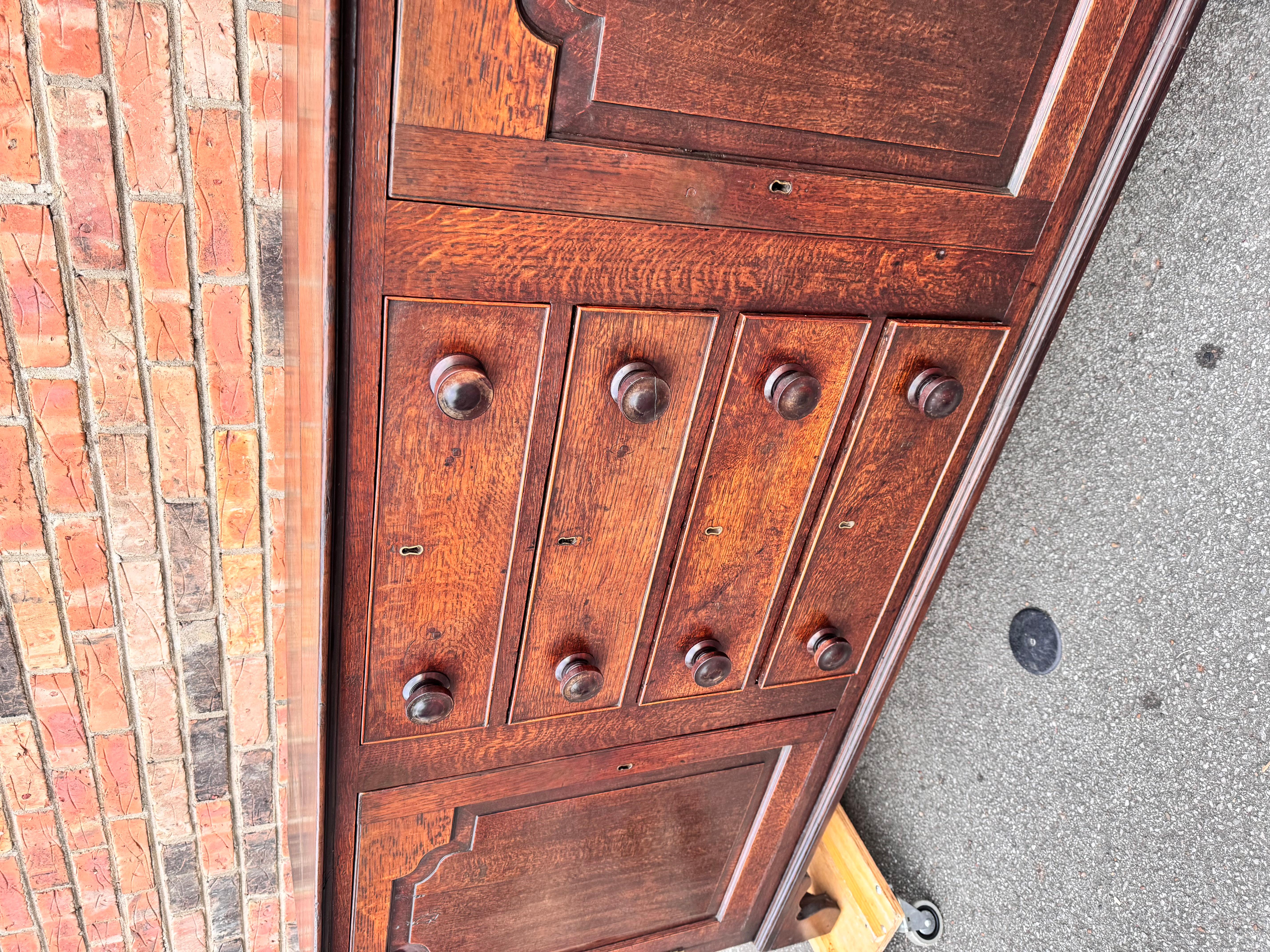 This is a fabulous early 19th century English dresser base with two beautifully carved doors that open to an ample amount of storage four drawers with the original wood knobs that slide effortlessly. The end panels are decorative as well. The top