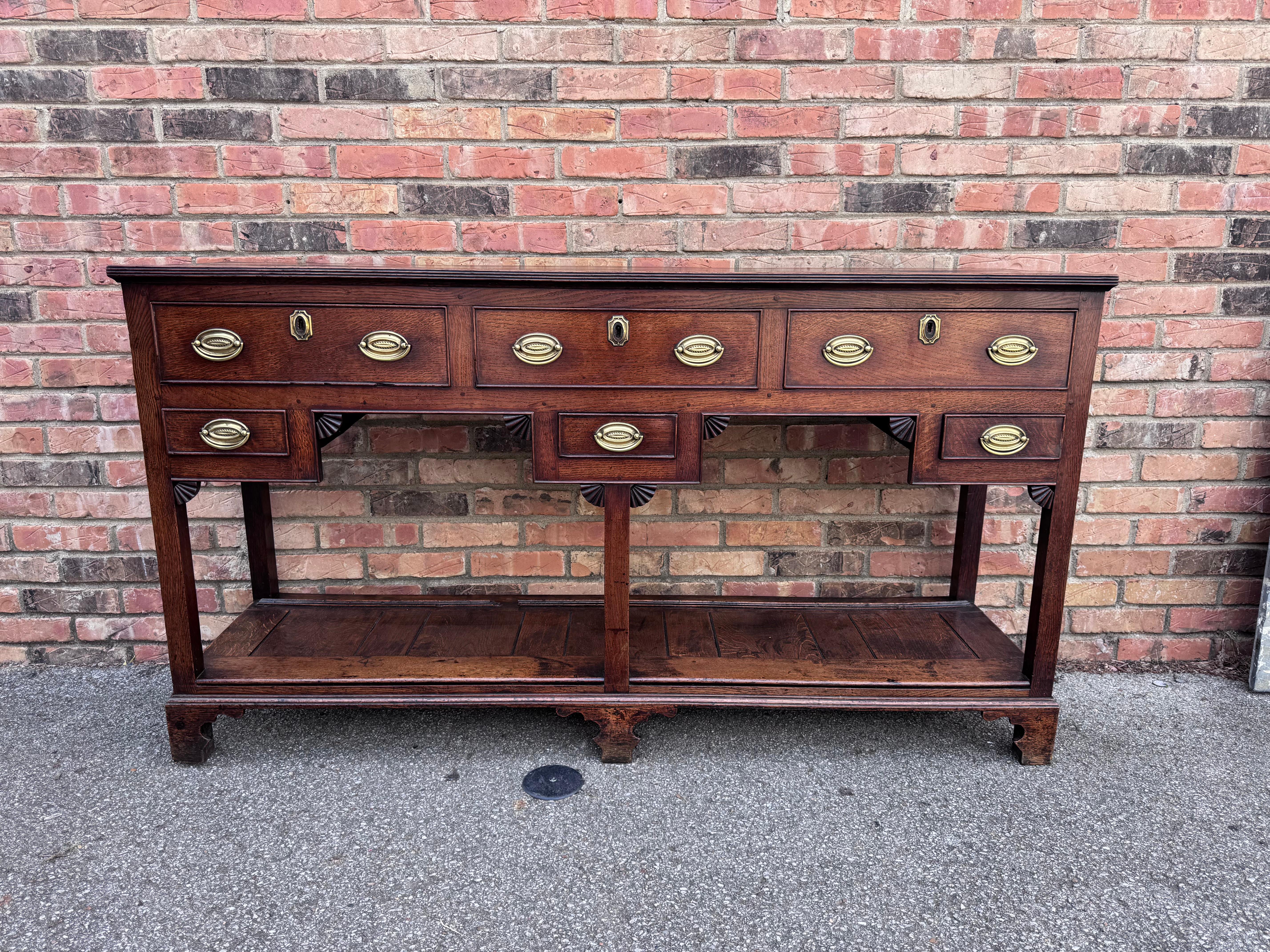 Posee un pedazo de historia con esta Base de Cómoda Galesa Inglesa de principios del siglo XIX con Tablero para Ollas. Fabricada con un encanto intemporal, esta cómoda antigua irradia sencillez rústica. La robusta construcción de madera y su cálida