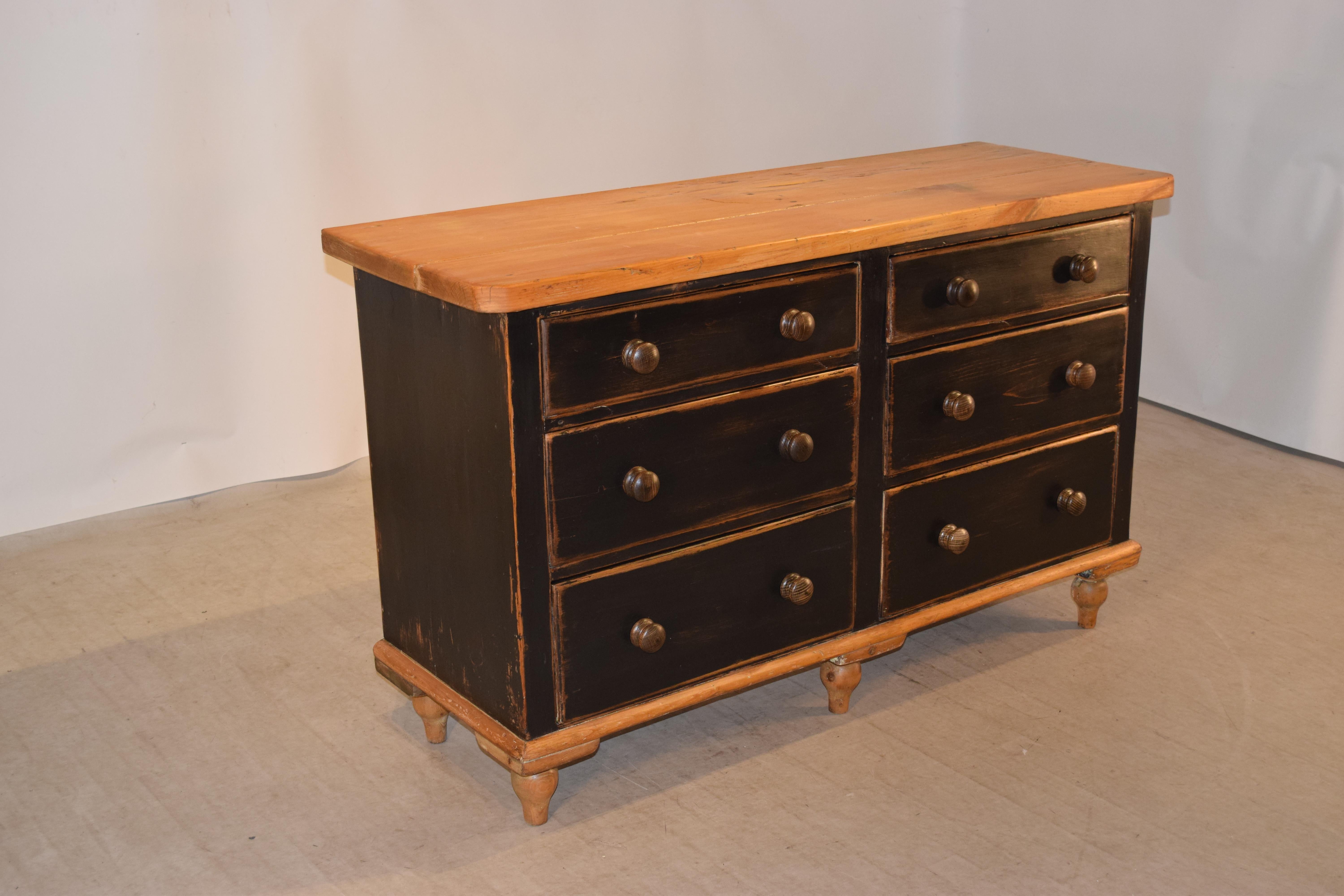 19th century pine dresser base from England with a thick top following down to simple case containing six drawers over a simple molding and hand-turned feet.