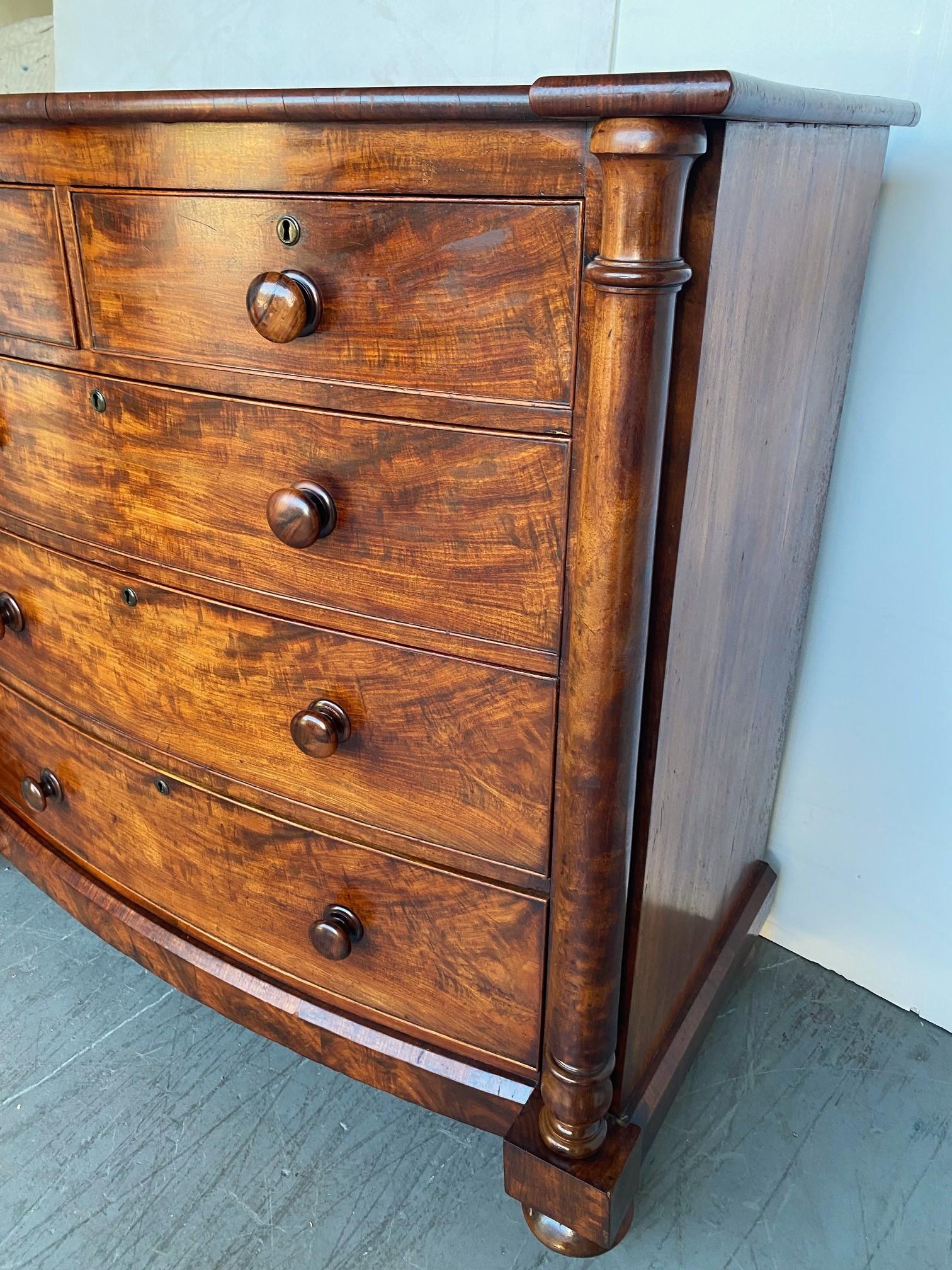  An English Mahogany Dresser / Chest of drawers. Superb crotch mahogany graining to the drawers and bottom plinth. All original wooden knobs, brass lock escutcheons, and brass casters. c.1840
