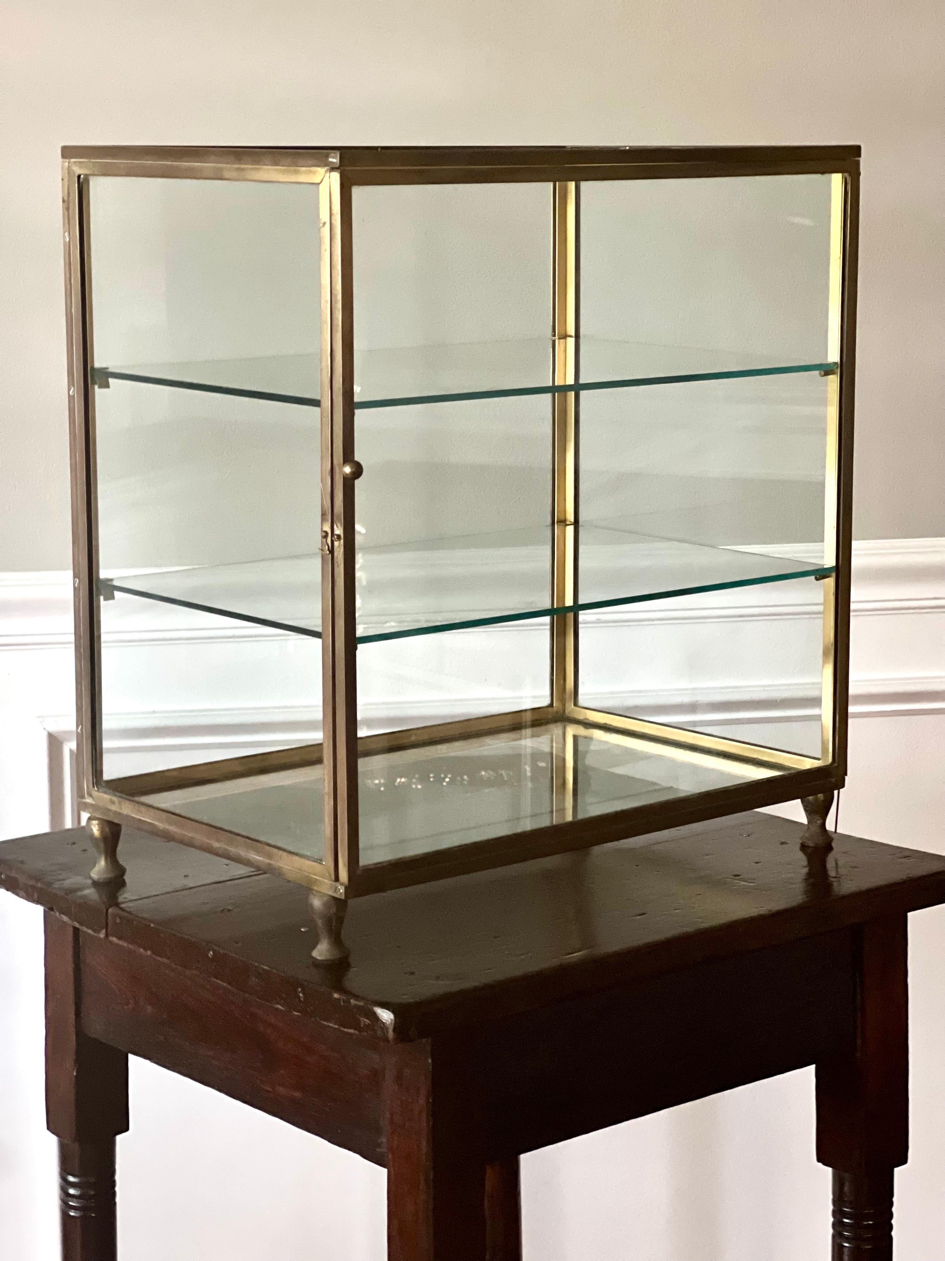 Rare English Early Modernist polished bronze shop display cabinet or tabletop vitrine, circa 1890.

Originally used as a display case in a boutique, this exquisite vitrine features six sides of glass with two glass shelves and a sturdy, polished