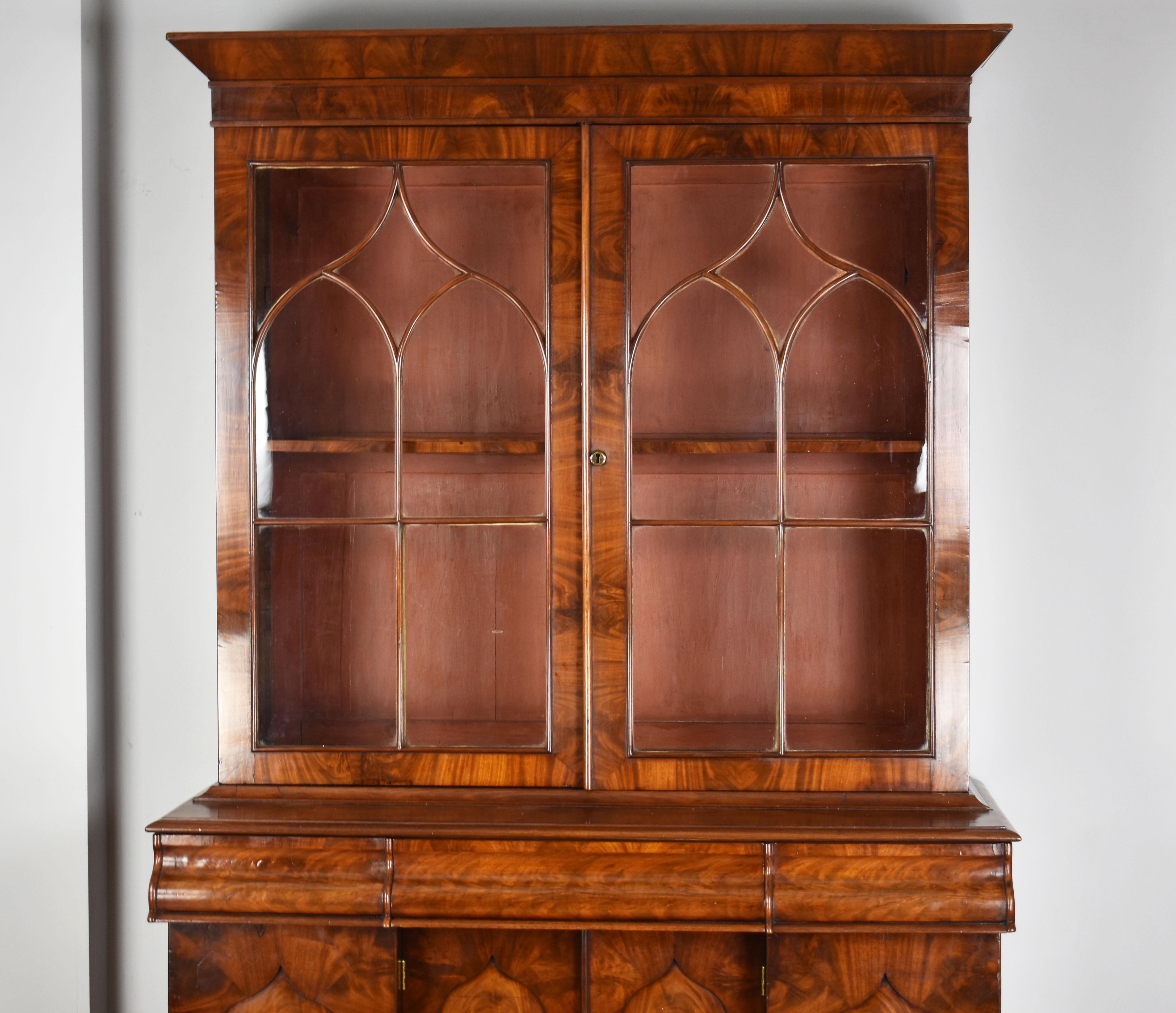 For sale is a superb early Victorian flame mahogany bookcase. The top having two nicely glazed doors opening to two adjustable shelves, above three drawers with a cupboard base below. The bookcase is raised on a plinth base and remains in very good