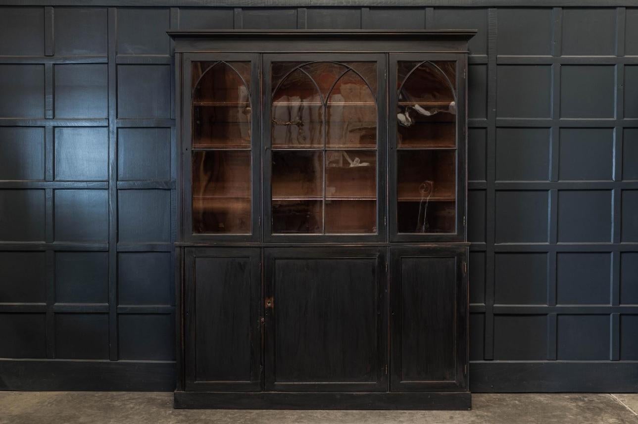 19th Century English ebonized mahogany estate made arched glazed bookcase, circa 1880. Excellent scale with original brass hardware, handblown glass and locking key. Adjustable top cabinet shelving. There are three glass doors on the upper cabinet;