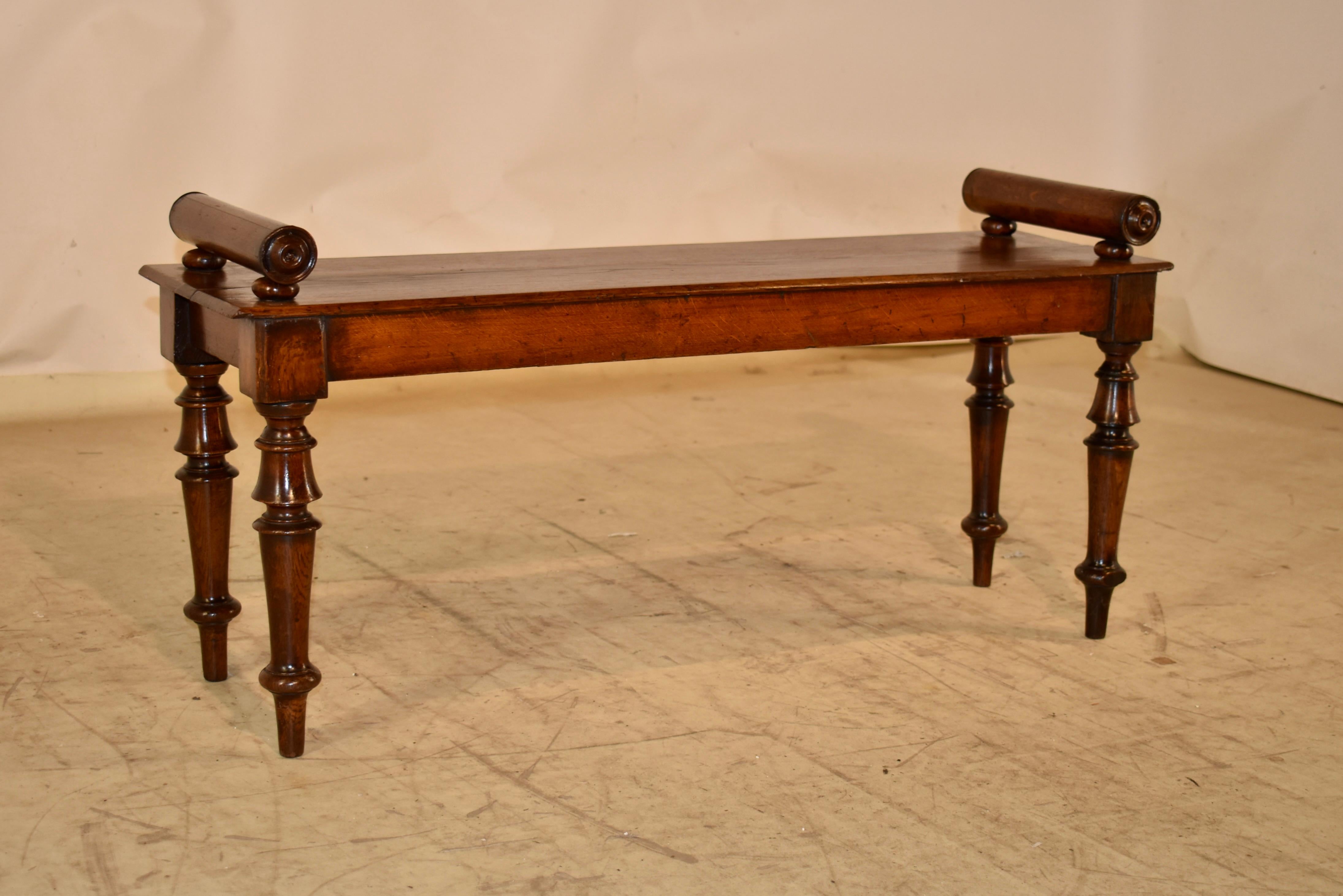 19th century elm and mahogany window seat form England. 

The seat is made from two nicely grained boards and supports two hand turned arms on either end.  The seat measures 17 inches in height.  

The seat follows down to a simple apron and is