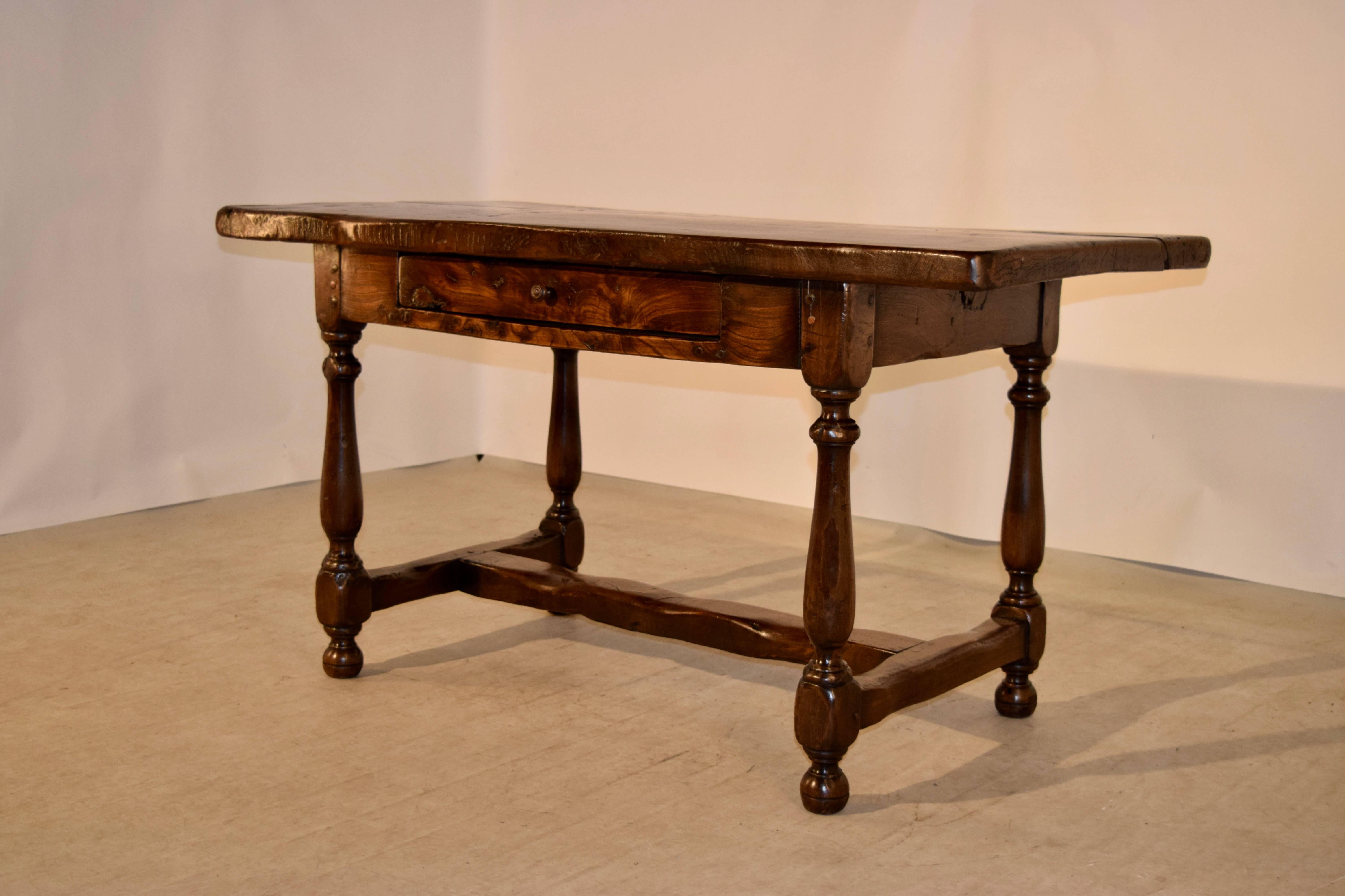 19th century elm table from England. The tabletop is one enormous single plank, which has normal shrinkage for its age. The base is simple and has pegged construction and a single drawer in the front and the piece is supported on hand-turned legs,