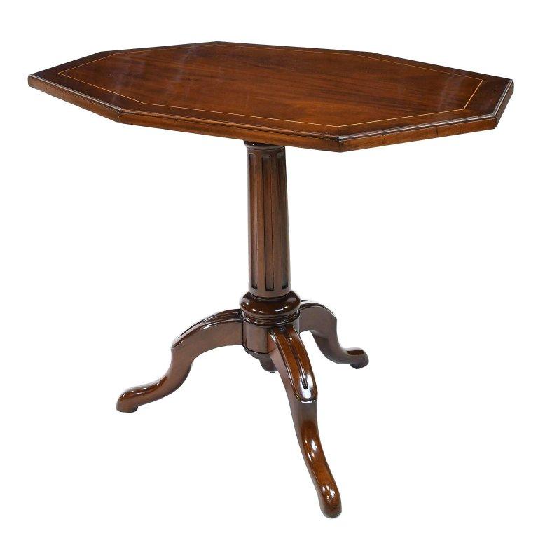 A rather unusual small table in mahogany with octagonal top and satinwood line inlay with mahogany banding resting over a tripod base with fluted column. Table has a tilt-top mechanism which would have allowed it to tuck away in the perimeter of the