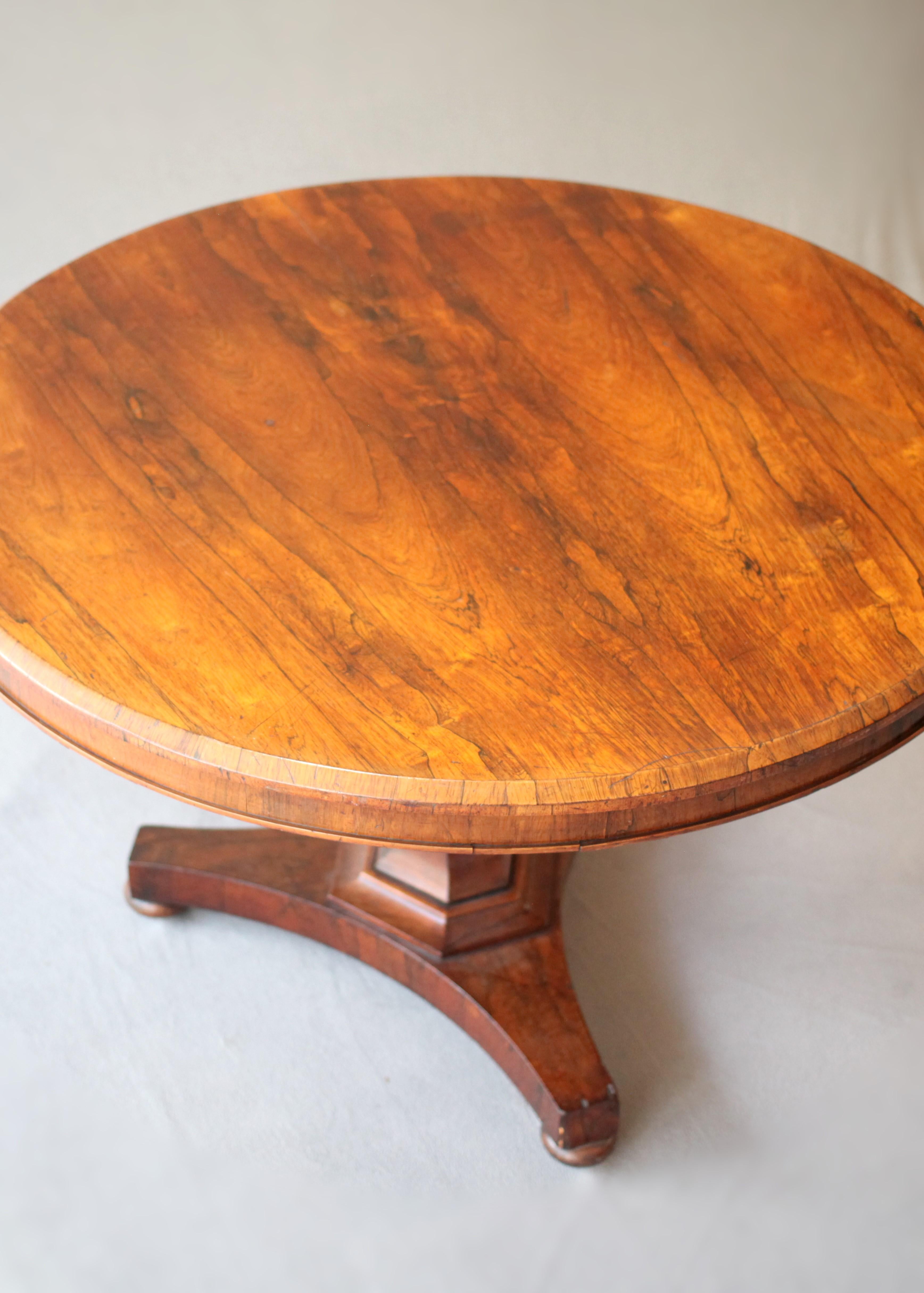 This 19th Century English Empire Walnut Centre Table is an iconic representation of timeless English craftsmanship. At the heart of its appeal is the attractively rendered walnut surface that exudes a warm, inviting hue. The harmonious marriage of