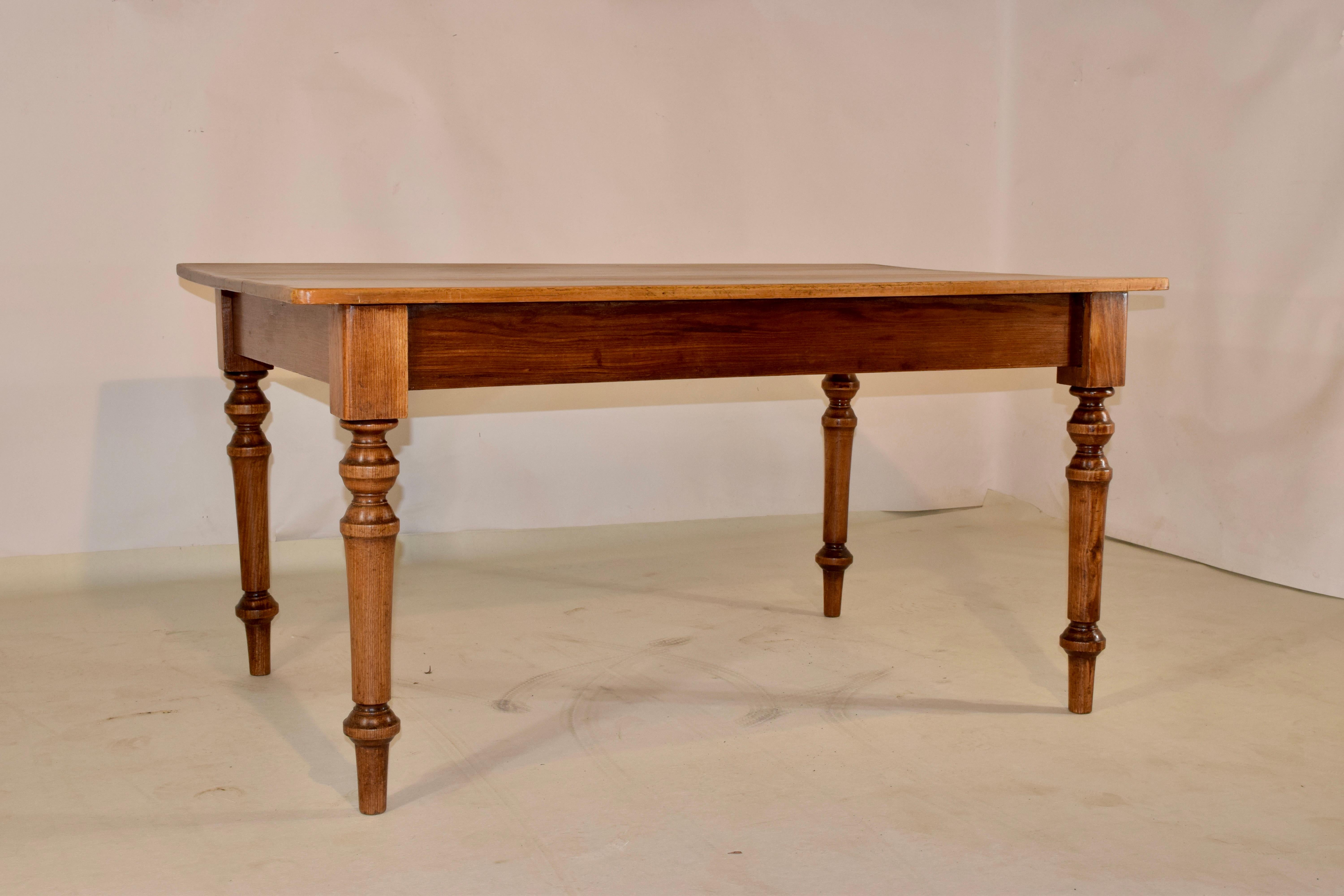 19th century English farm table with a pine top and oak base. The top is wonderfully colored and grained, over a simple apron, which measures 24.25 inches in height. The table is supported on hand turned legs.