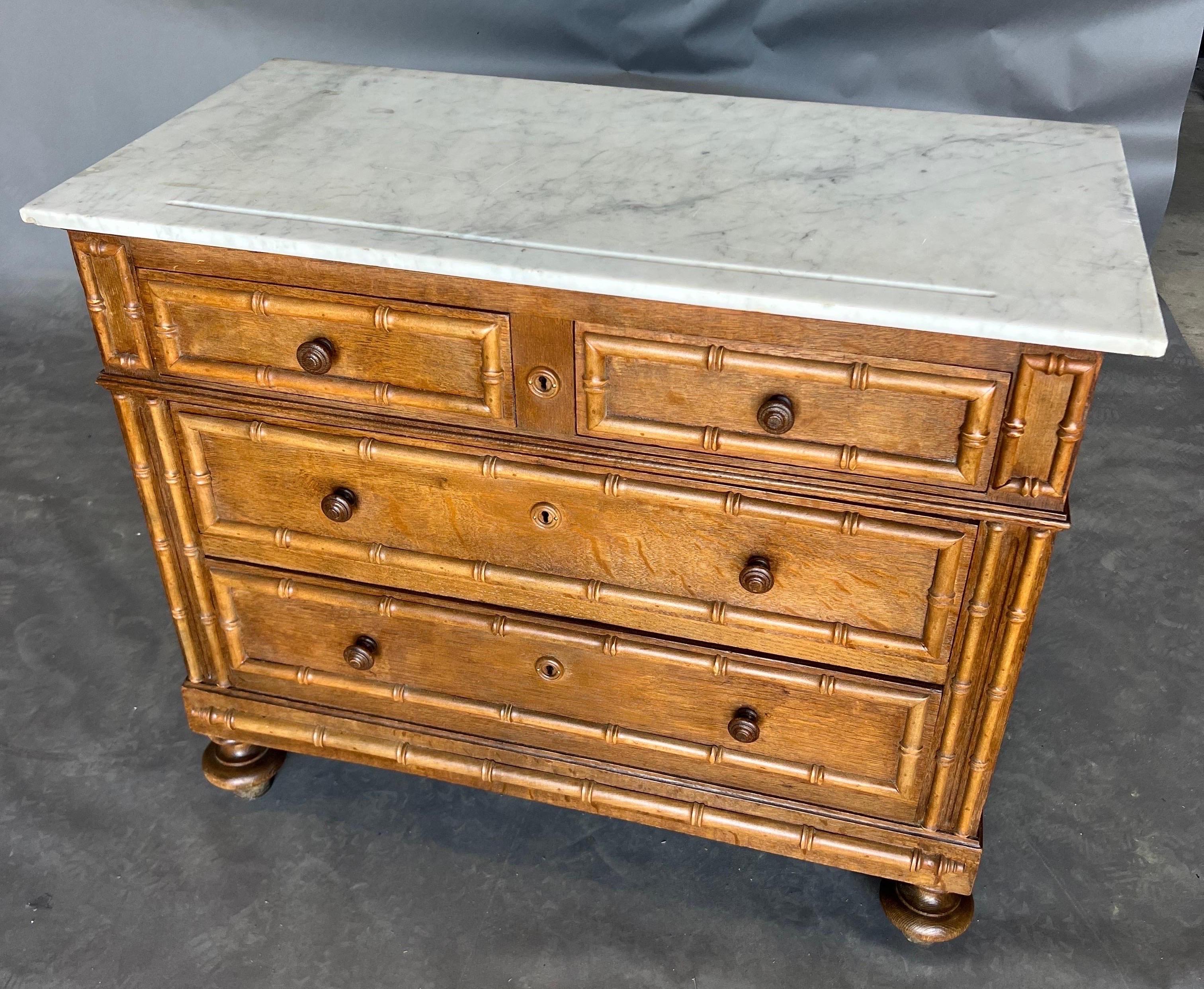 Great little 19th century English faux bamboo chest with original white marble top. Two drawers over two on turned feet.