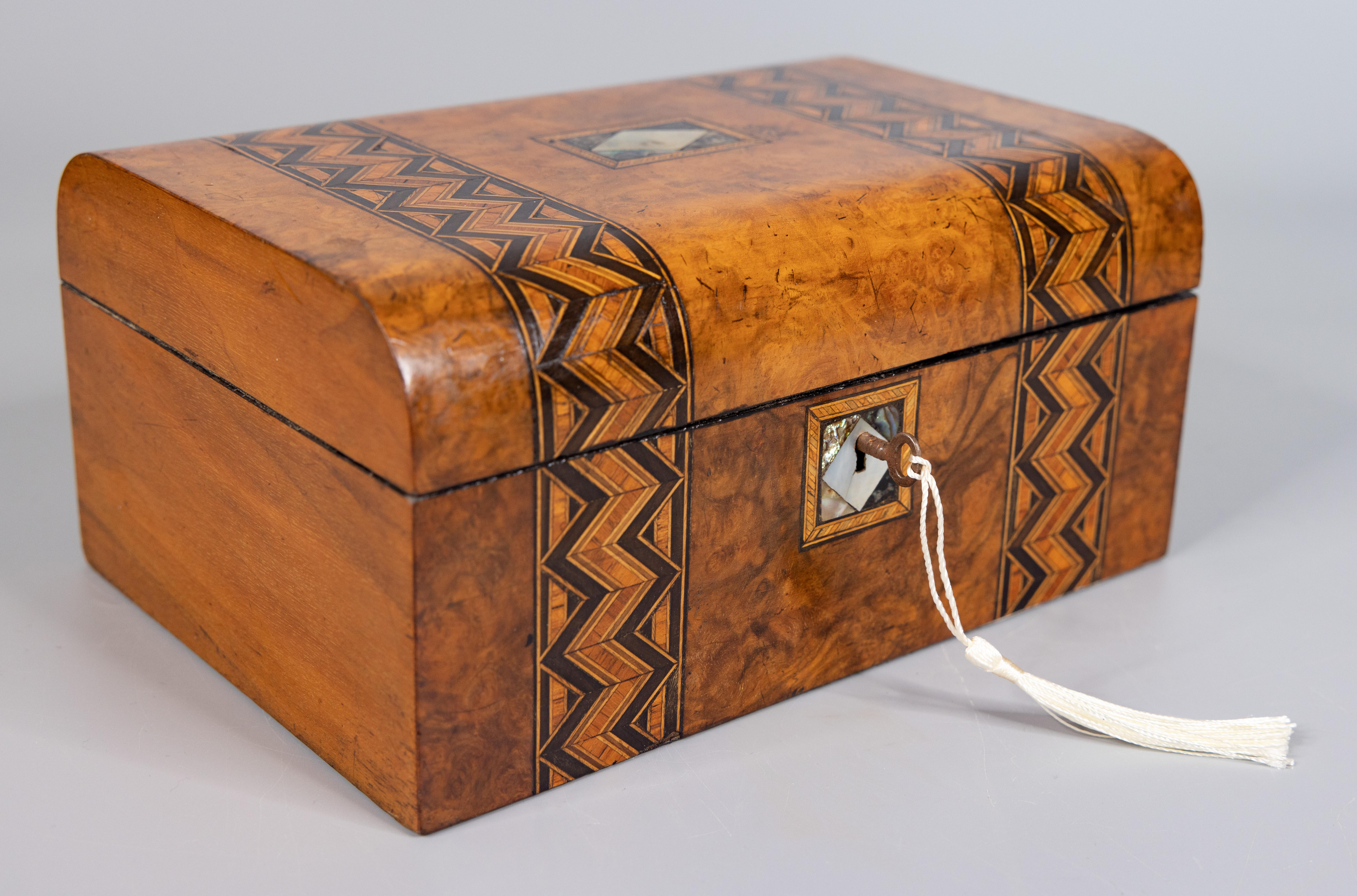 A superb 19th century English figured walnut box with lock and key, circa 1880. This fine antique box has a wonderful domed lid accented with tunbridge bands along the top and front with a mother of pearl center and key plate. This hand crafted box