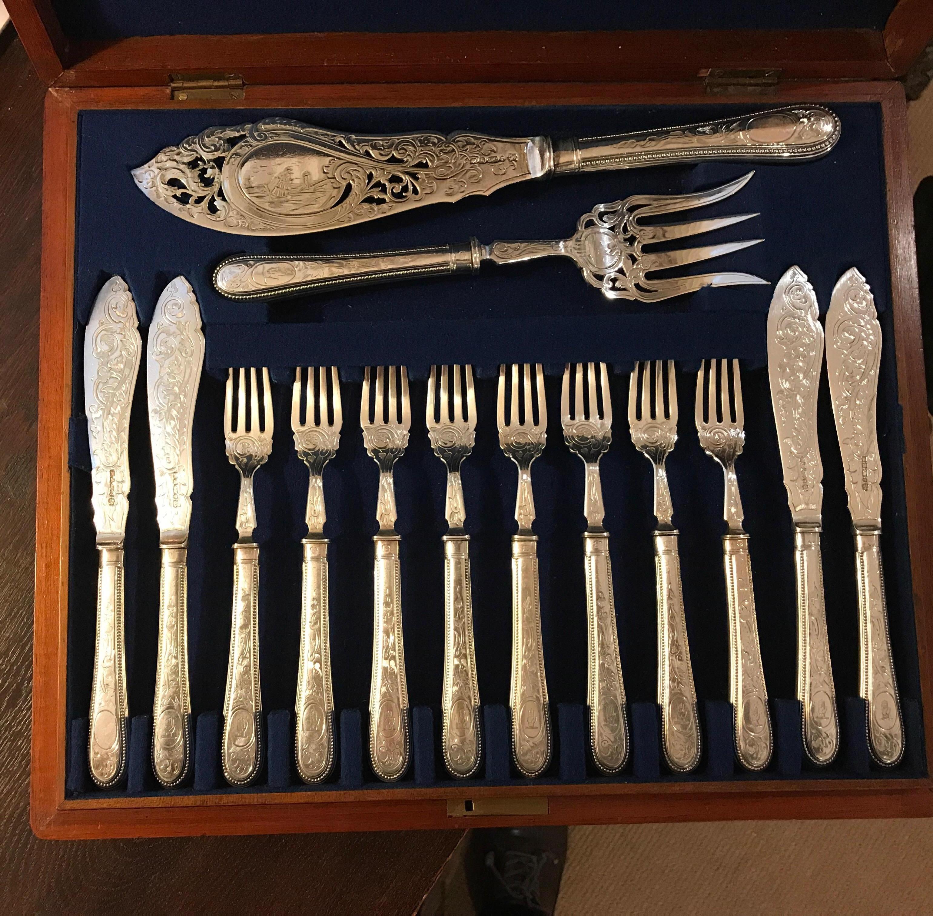 Elegant English fish service with 18 forks, 17 knives, plus large 2 pieced fish serving pieces. The mahogany box, with brass shield plaque with three trays with the silver plated and engraved fish set. Each piece has a full set of English hallmarks
